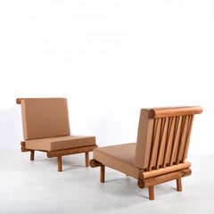 Pair of oak fireside chairs called La cachette, attributed to Charlotte Perriand