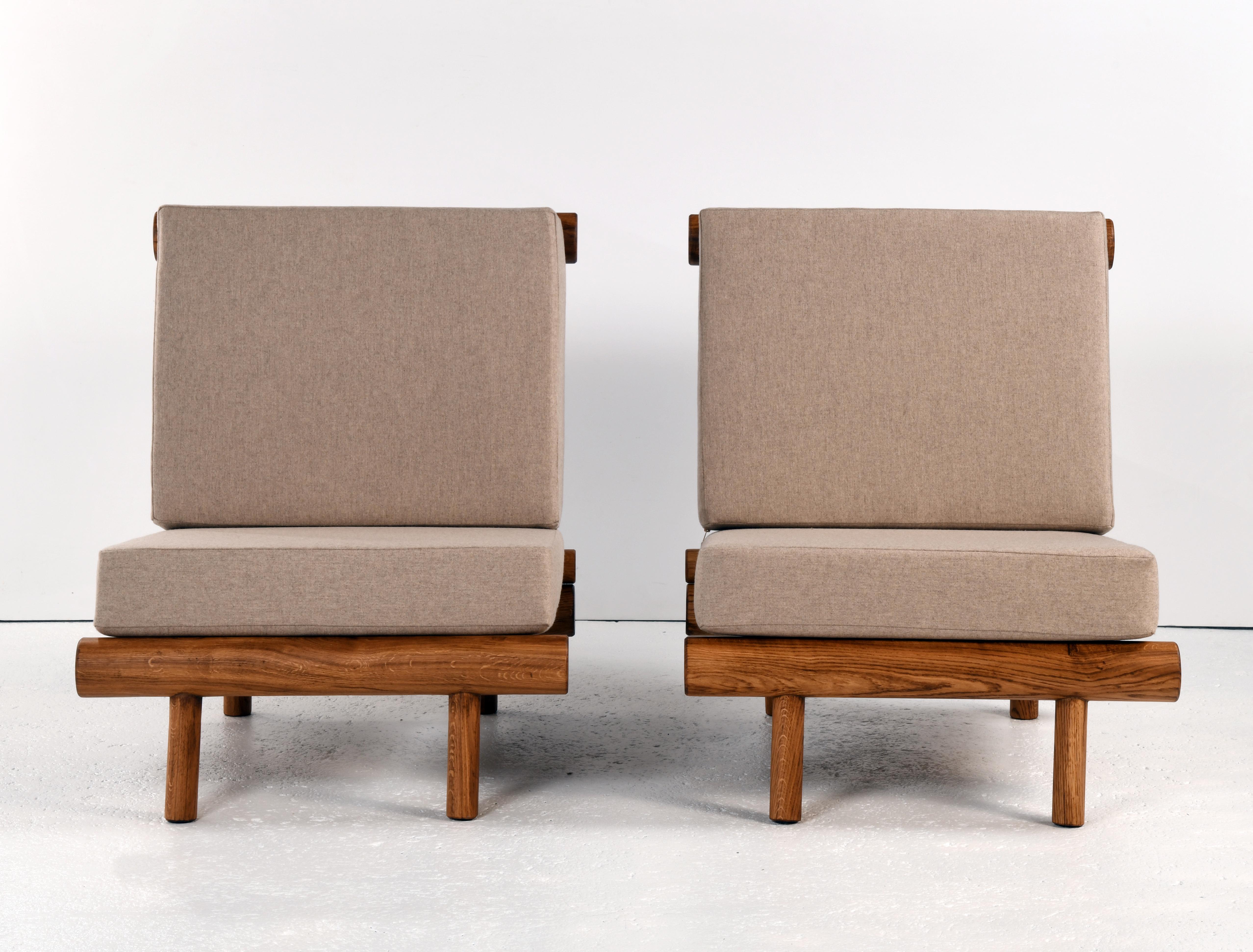 French Pair of oak fireside chairs called La cachette, attributed to Charlotte Perriand