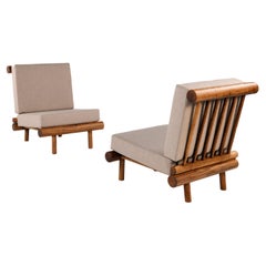 Pair of oak fireside chairs called La cachette, attributed to Charlotte Perriand