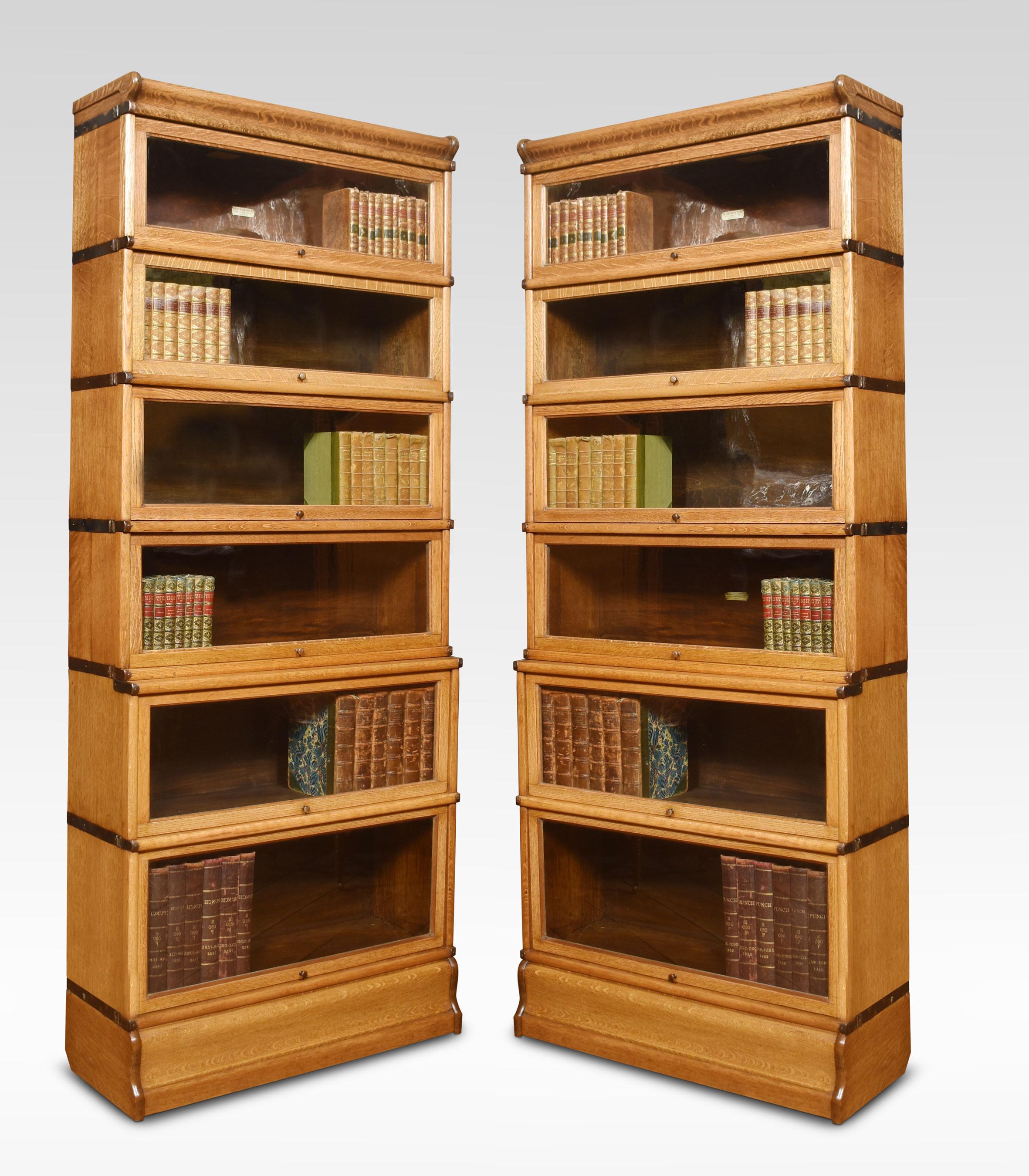 Pair of oak globe Wernicke six-section bookcases, the moulded top above six graduated sections all having glazed doors, raised up on plinth base.
Dimensions
Height 82 Inches
Width 34 Inches
Depth 12.5 Inches.