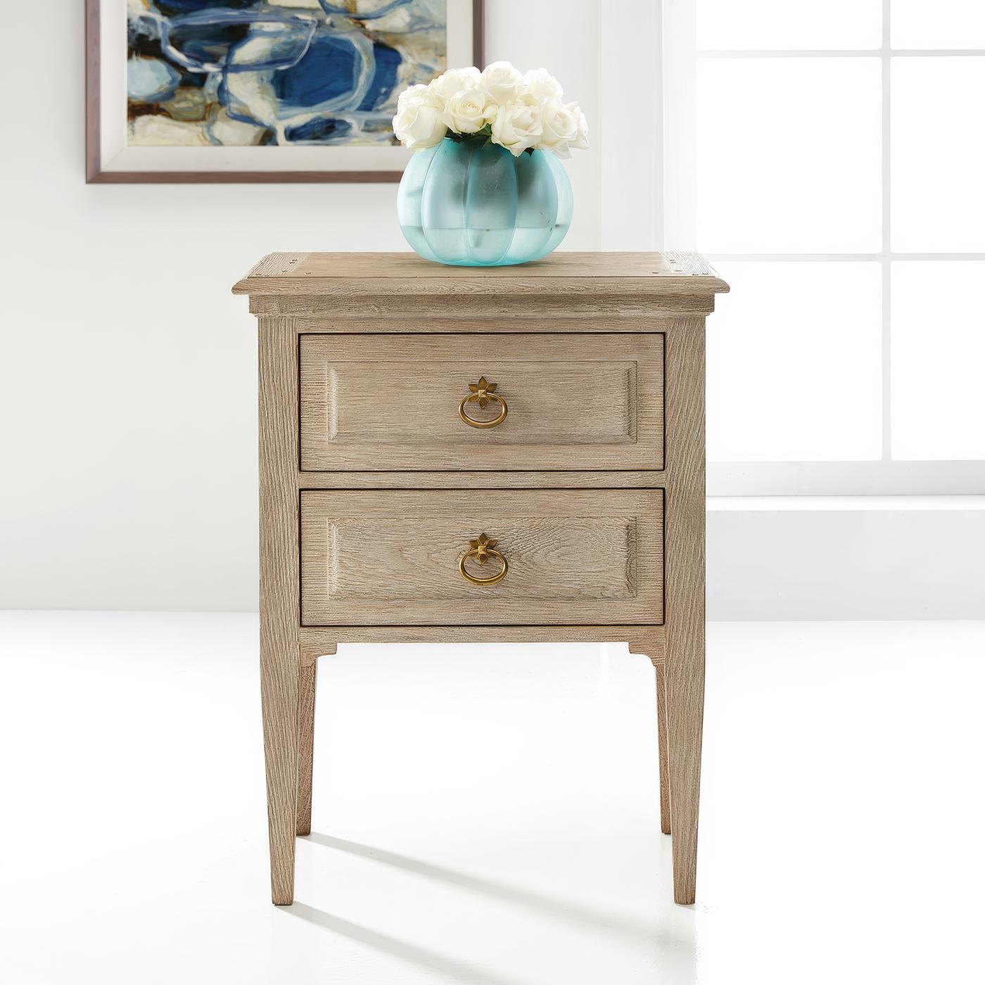 Masterfully crafted in weathered oak to reflect authentic 18th-century design.  

The two drawers feature refined panel detailing and are adorned with star-accented brass ring pulls that add both functionality and period authenticity. Perfect for