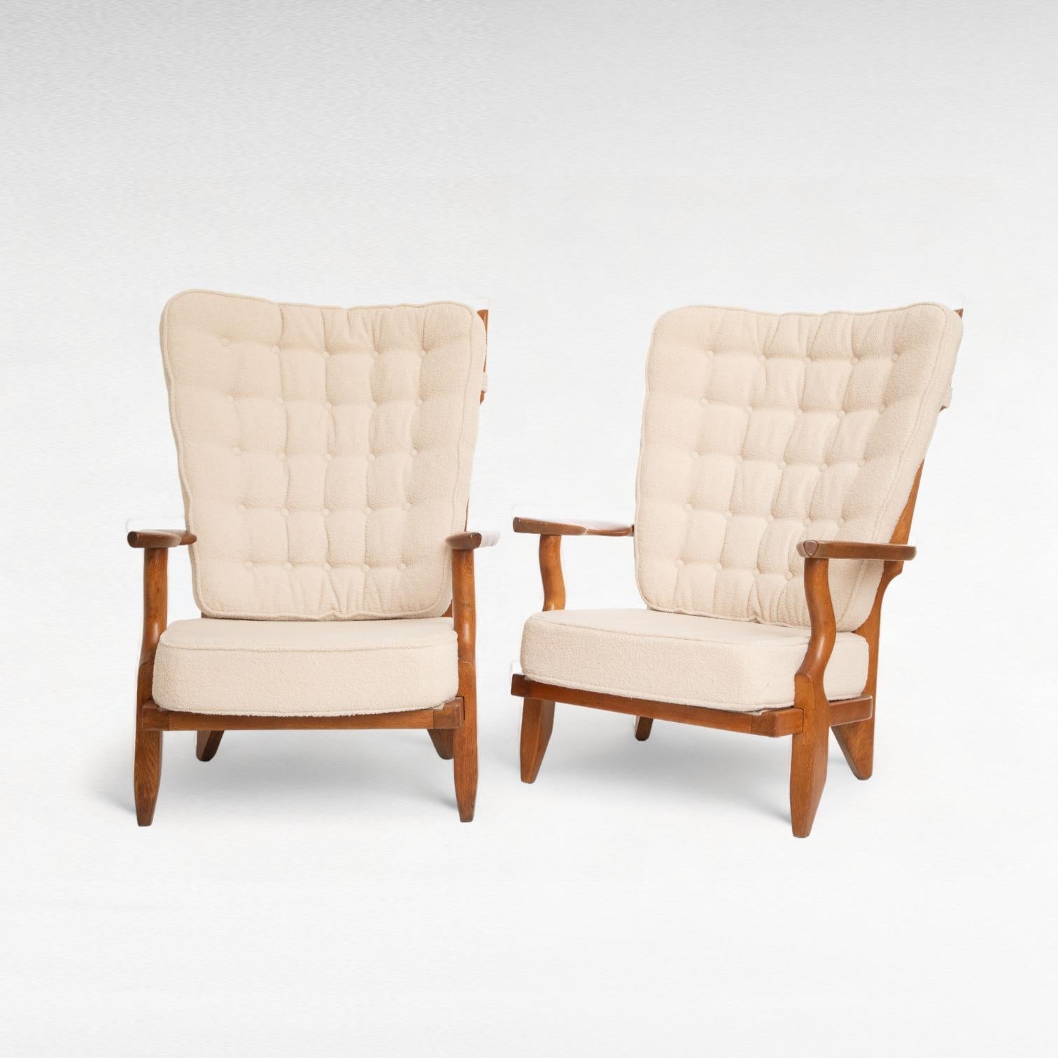 Pair of mid-century modern oak lounge chairs 
 by Guillerme et Chambron, 
France 1950
Model Grand Repos
Sculptural organic shape, finger back 
Retains a beautiful warm patina
These chairs are newly upholstered with an ecru microfiber boucle, with