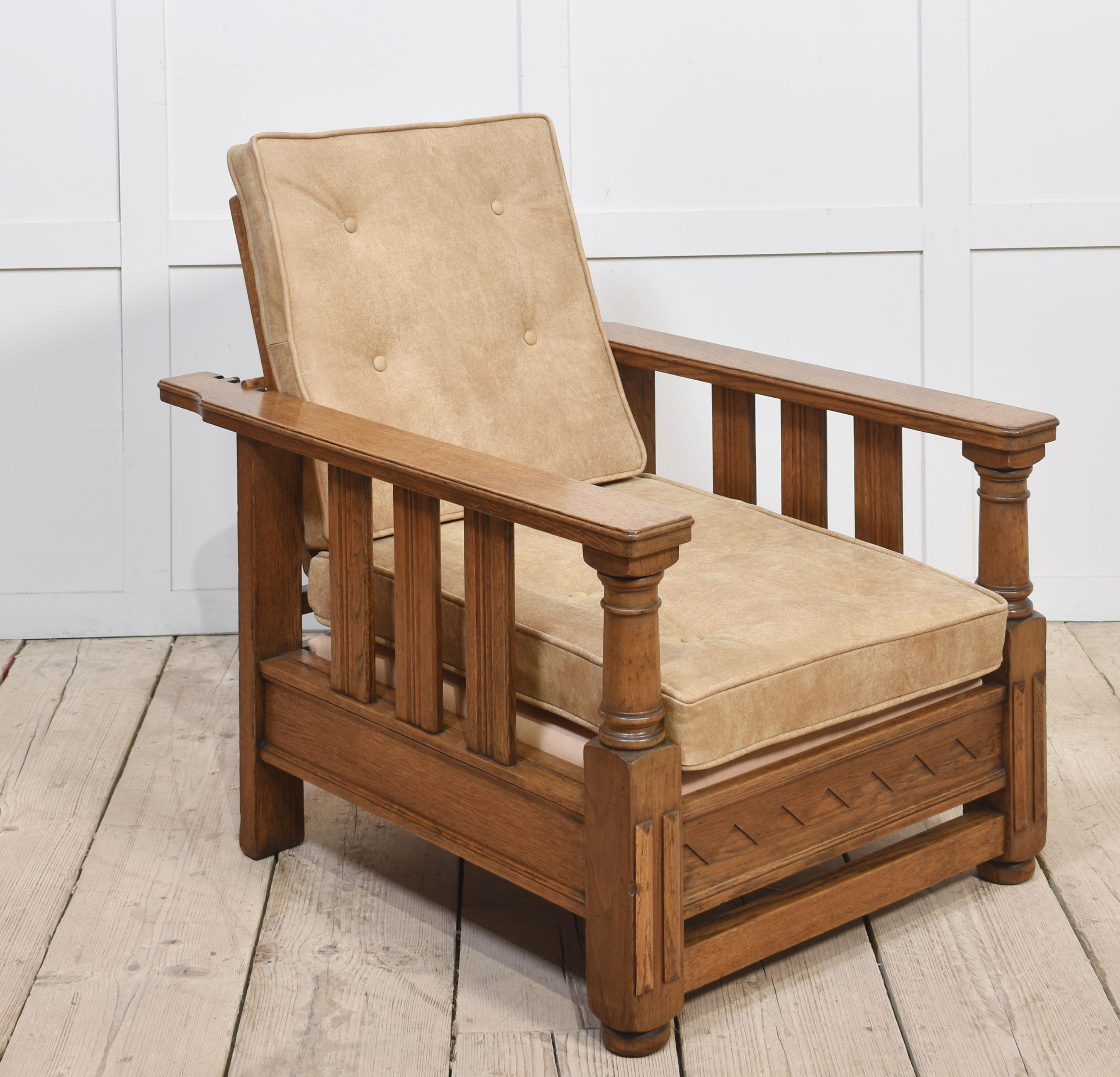 Pareja de sillones reclinables de roble de principios del siglo XX, cada uno con respaldo de escalera ajustable, brazos alargados y laterales de listones con cojines tapizados en piel extraíbles. Todos levantados sobre pies