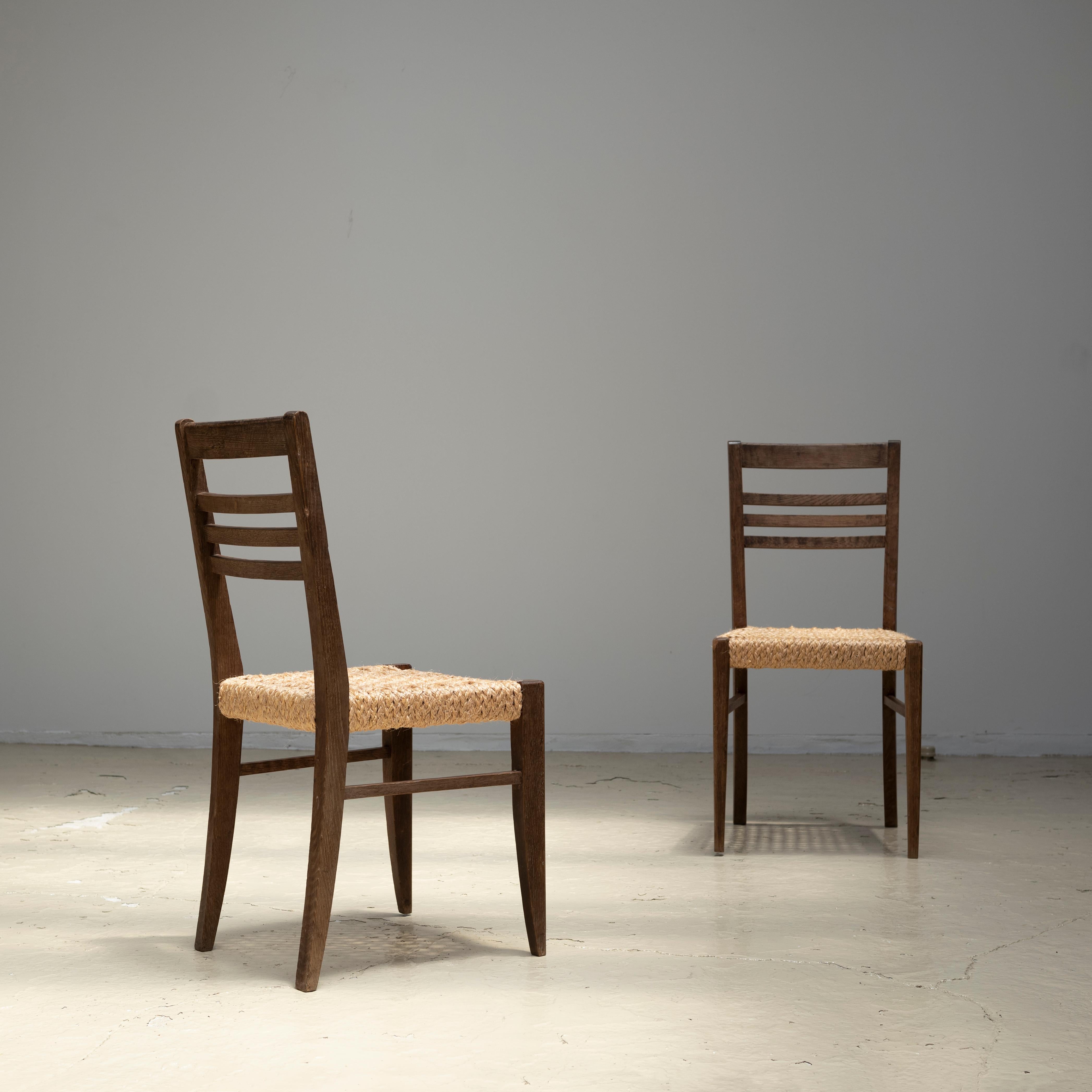 Ein Satz von zwei Esszimmerstühlen, entworfen von Adrien Audoux und Frida Minet in den 1950er Jahren.
Besteht aus einer Eichenholzstruktur und einem Sitz aus geflochtenem Seil.
Wird als Paar verkauft.