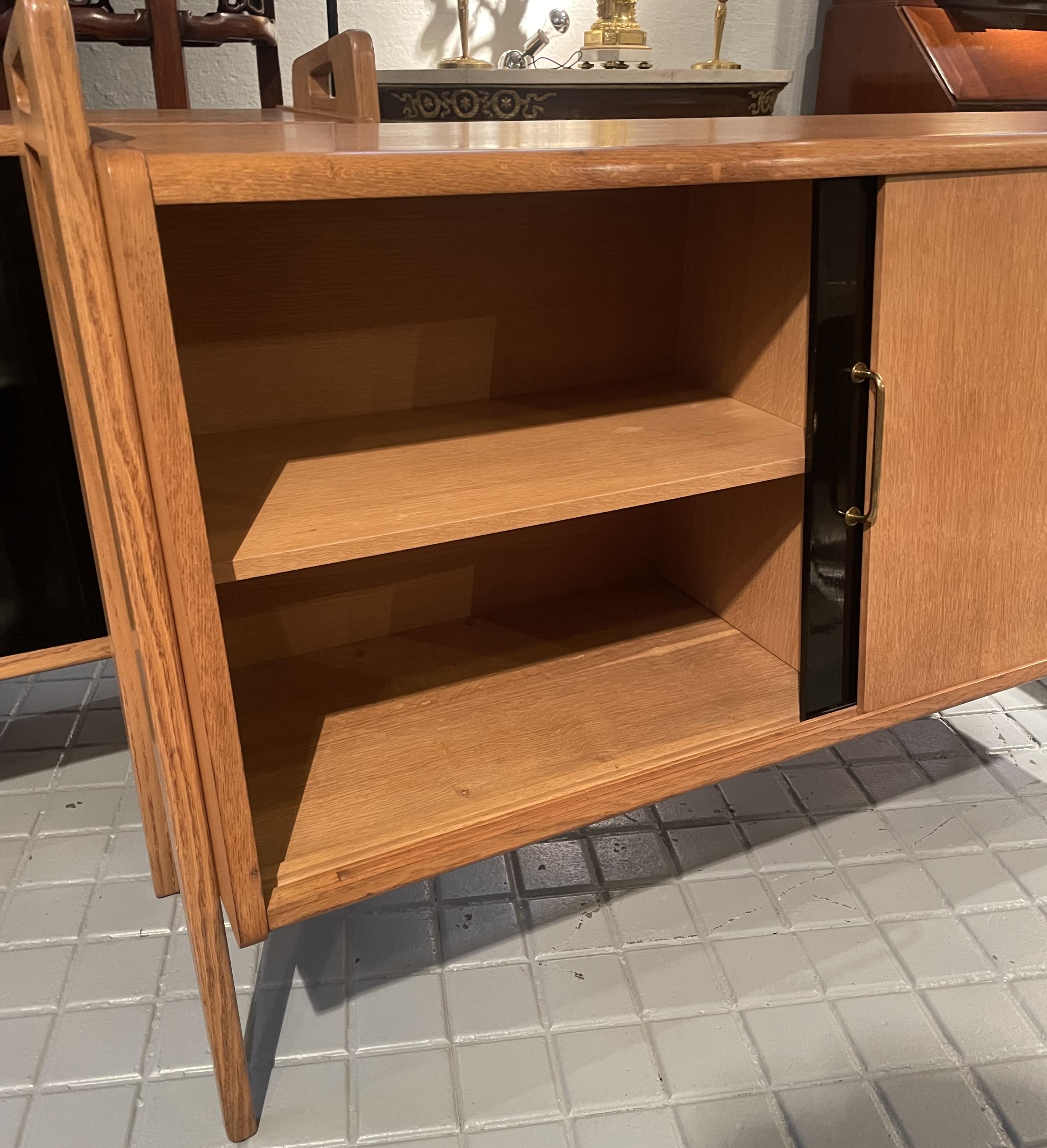20th Century Pair of oak sideboards with sloping front, sliding doors, one of them lacquered For Sale