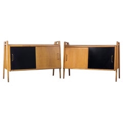 Pair of oak sideboards with sloping front, sliding doors, one of them lacquered