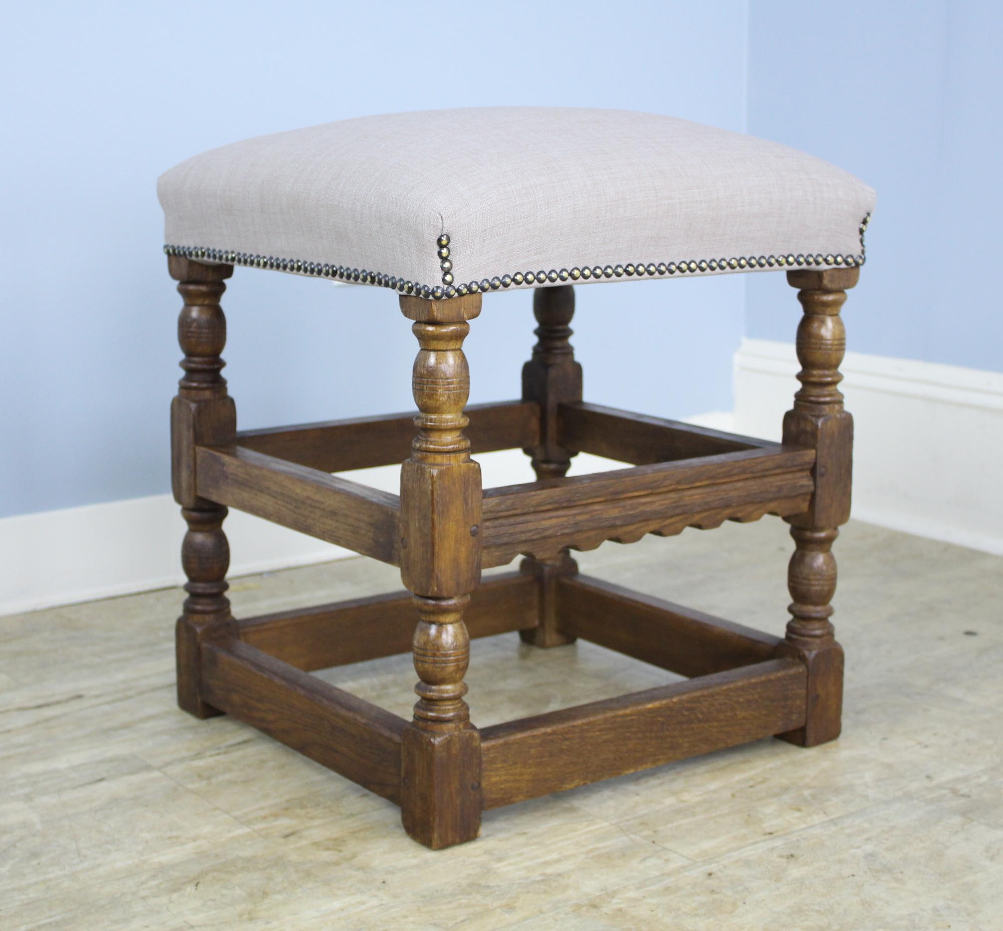 A charming pair of oak turned leg stools, newly upholstered in French linen. Highly decorative!