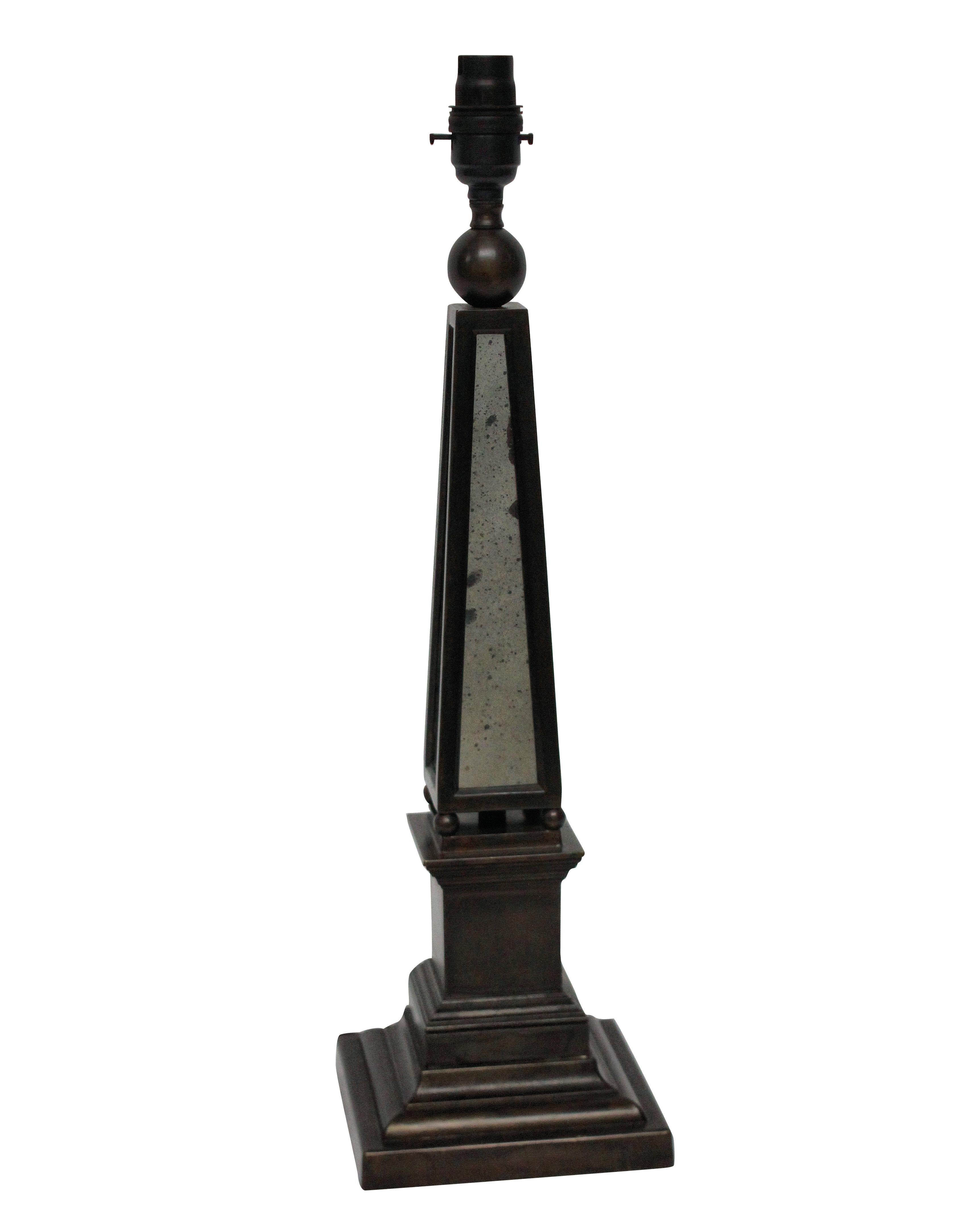A pair of English bronzed obelisk lamps with distressed mirror panels.