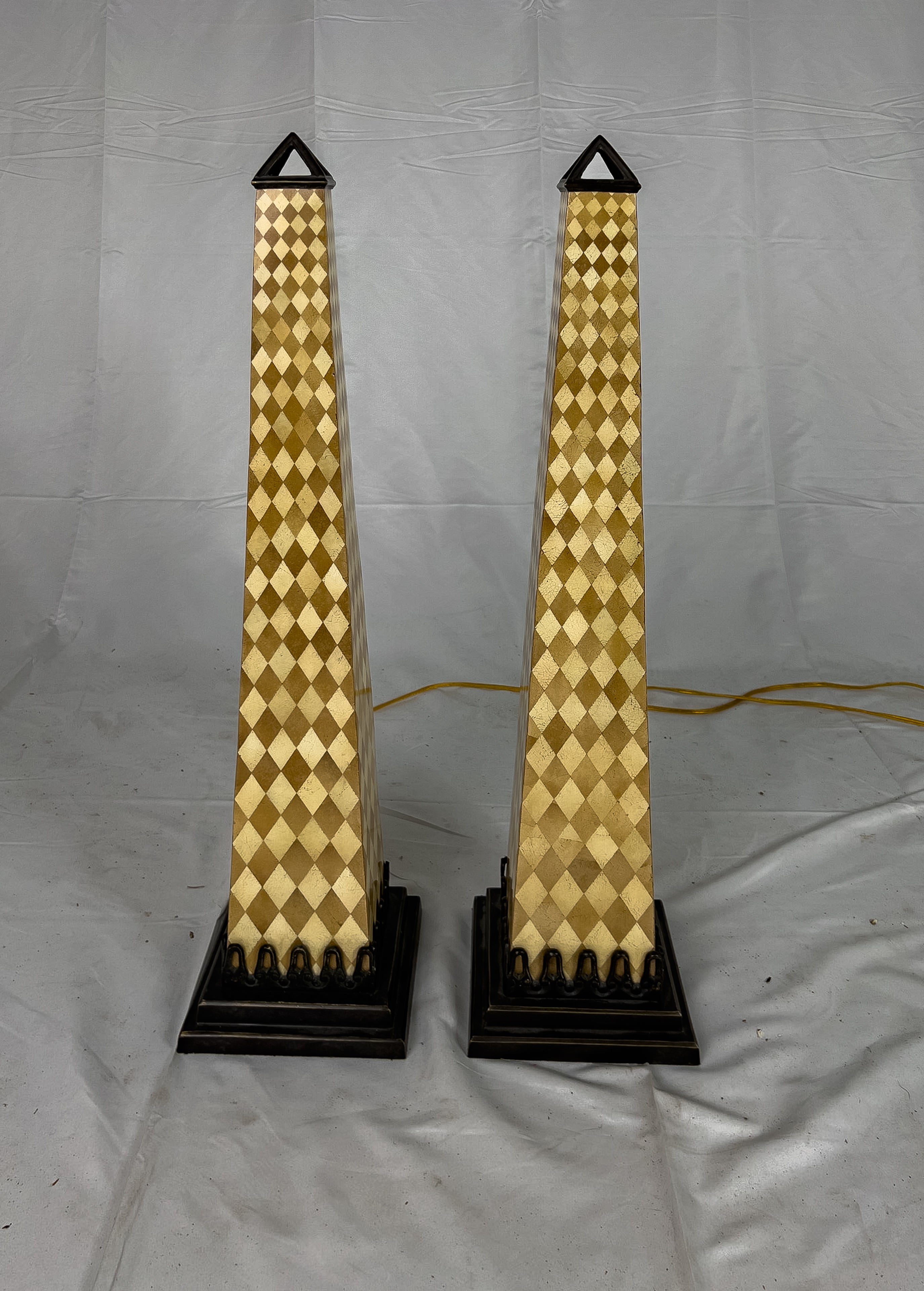 Pair of Obelisk table lamps having a harlequin pattern resin body and bronze colored metal cap and base. This lamp has a Type A plug type and is up to 120V (US Standard).