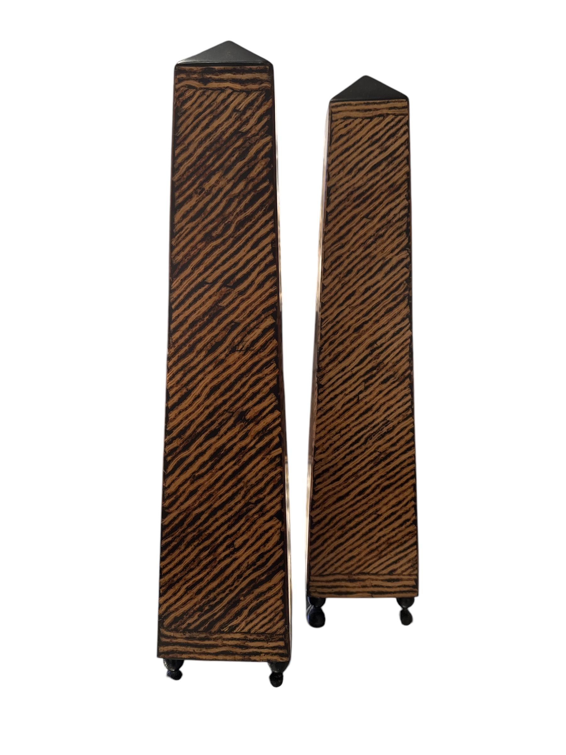 Pair of mid-century obelisks in zebra wood veneer, standing on small round feet