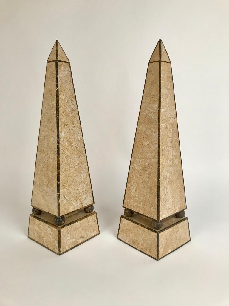 Pair of handsome and high quality stone veneered obelisks. Done in a pale travertine outlined with gray marble borders, the upper part raised on four marble balls above a rectangular plinth.Great for the mantle piece or as decorative objects for any