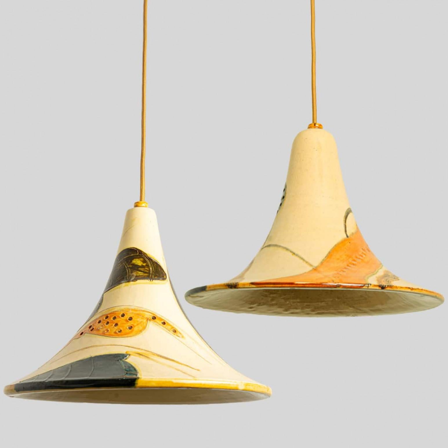 Stunning pair of hanging lamps with a cone shape, made with rich colored ceramics, manufactured in the 1970s in Denmark.

Height is adjustable. We can deliver any length and color of steel cable, texile cable or cord (in different colors) or chain