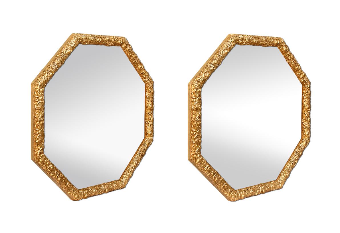 Pair of antique French octagonal mirrors with ornate wood molding and stylized stucco decorations. Re-gilding to the patinated leaf. Antique wood back. Modern glass mirror. Antique frame width: 3 cm.