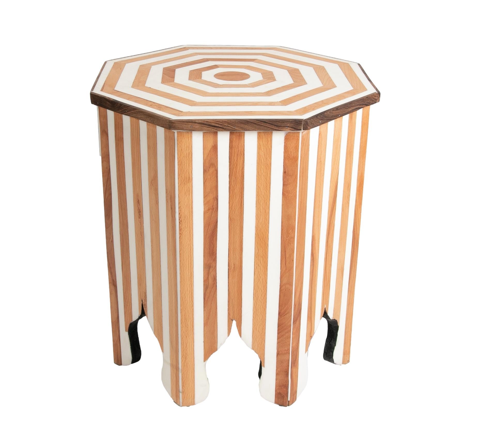 Pair of octogonal sidetables made in wood and resin. The top surface shows a concentric design that matches the stripes in the legs; both of them mix the natural color of the wood with the white from the resin creating a nice match.