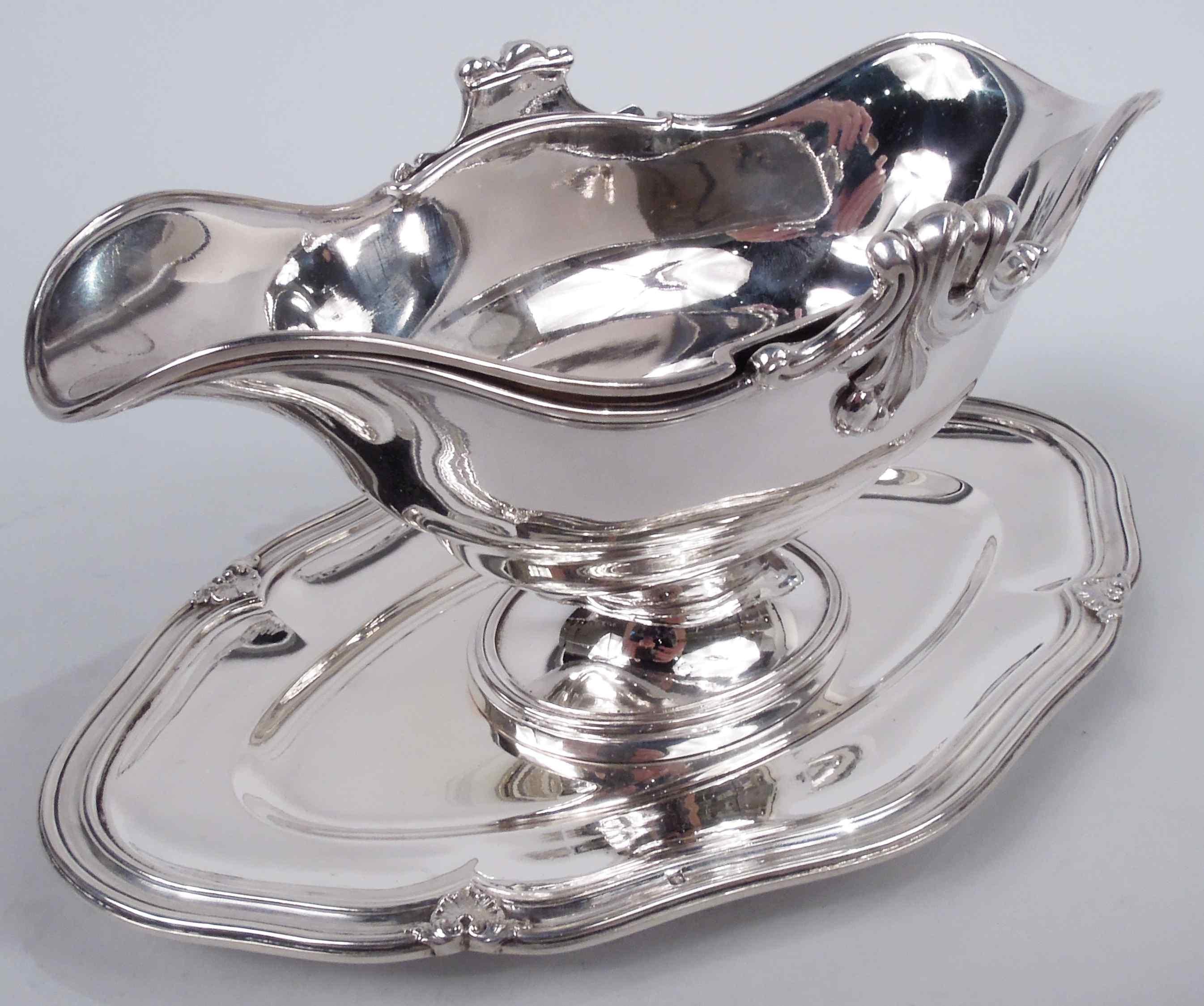 Pair of Belle Epoque Classical 950 silver gravy boats. Made by Odiot in France, ca 1900. Each: Ovoid with u-form end spouts and raised oval foot mounted to Oval shaped stand. Molded rims. Bowl sides have applied cast leafing scrollwork and stand rim