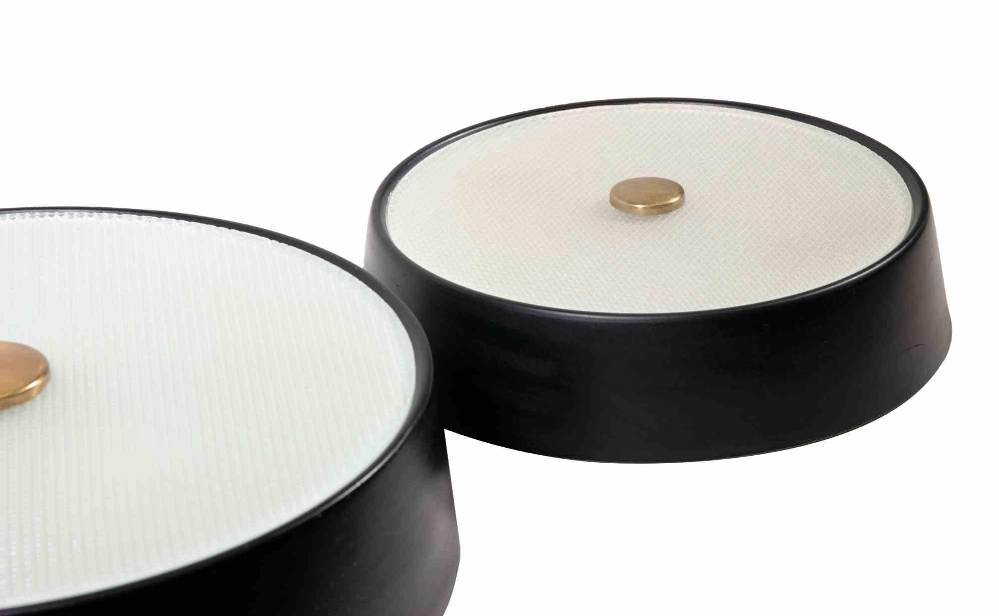 Pair of wall lamps is a design object realized by Stilnovo in the 1970s.

White Opaline Glass, Black Varnished Metal Structure, Brass details.

Stilnovo is an Italian company specializing in the production of lighting fixtures. 
Founded in
