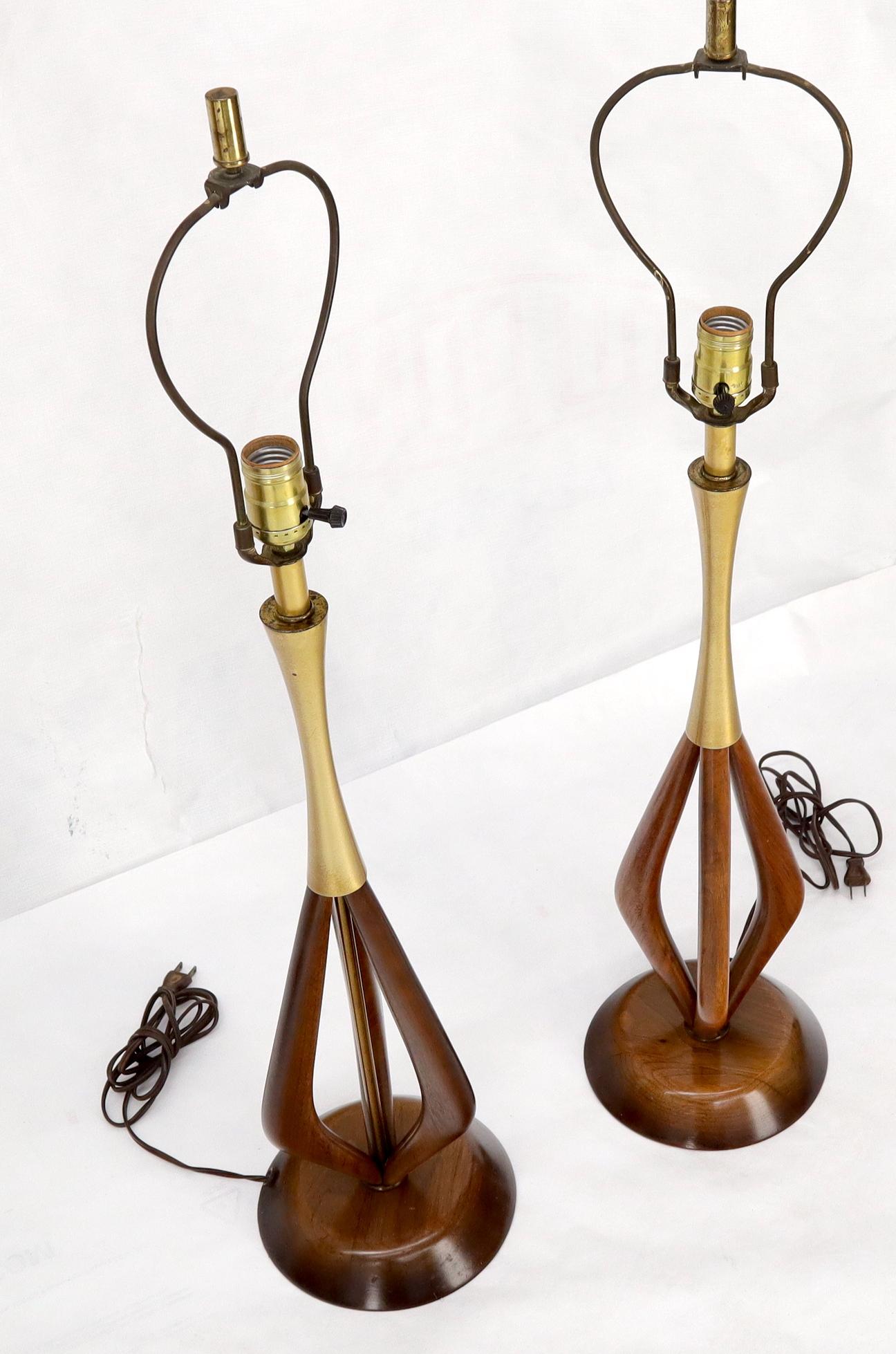 Pair of oiled walnut and brass Mid-Century Modern table lamps. Measures: Standing 34