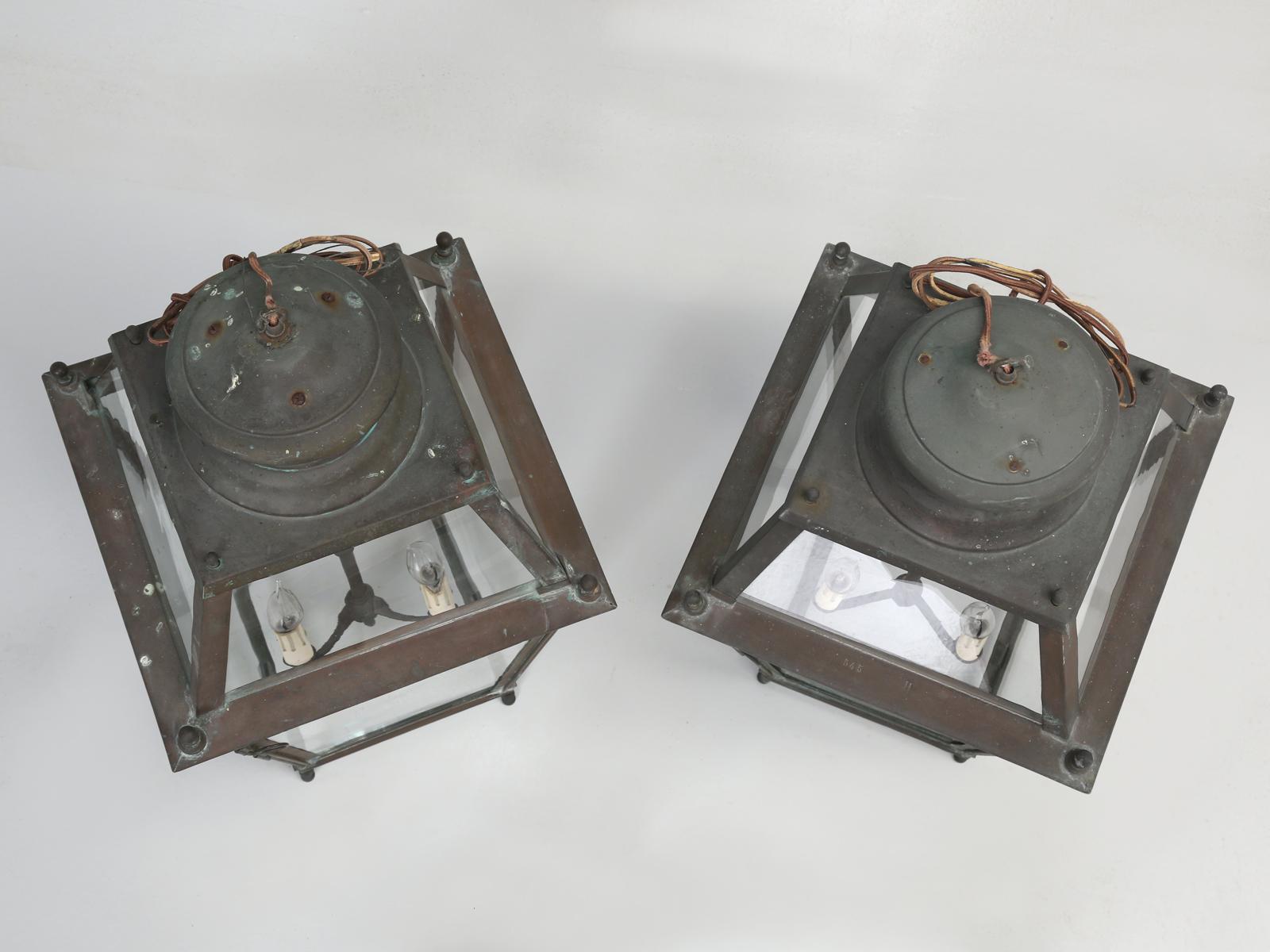 Pair of old French copper lanterns, that have been converted to USA standard candelabra bulbs and all new wiring has been installed in the antique French copper lanterns. The glass panes in the French lanterns are all original French wavy glass and