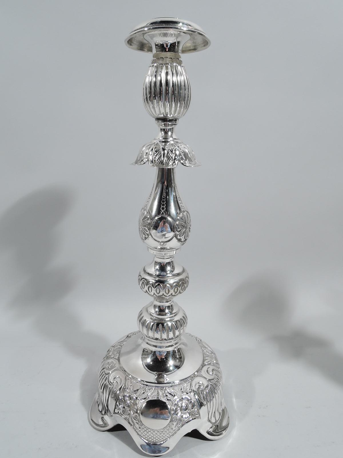 Pair of Old Country sterling silver candlesticks, ca 1920. Each: Baluster shaft with double knops and leaf flange on domed foot with deeply scrolled rim. Naïve ornament including flowers, shells, fish scales, and guilloche. In traditional Russian or