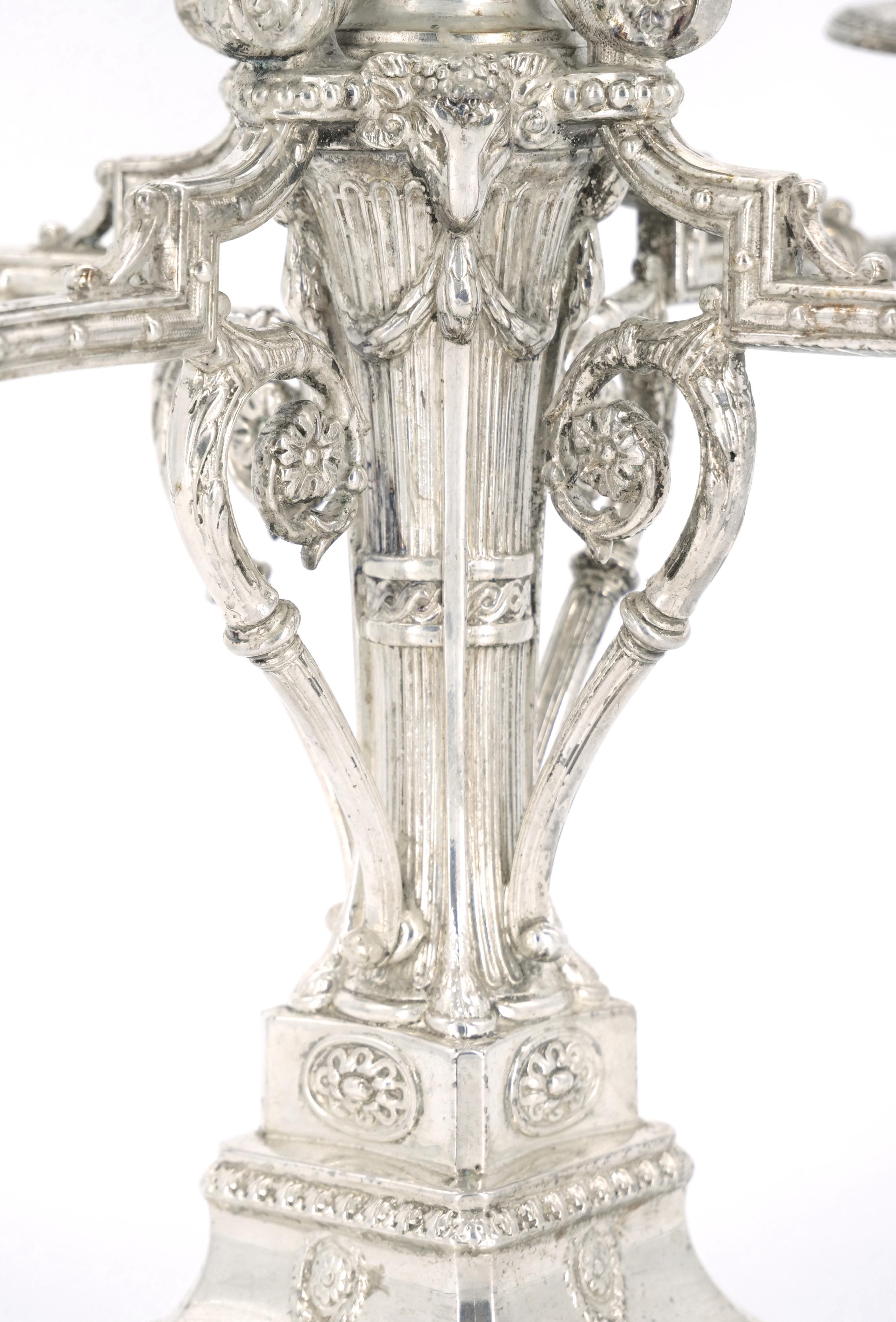 Exceptional pair of Victorian period Sheffield silverplate candelabra, circa 1860, with five candle arms with fine repousse and chased designs including bellflower swags, urns, foliate scrolls, rosettes and ram heads. Well-polished and ready for