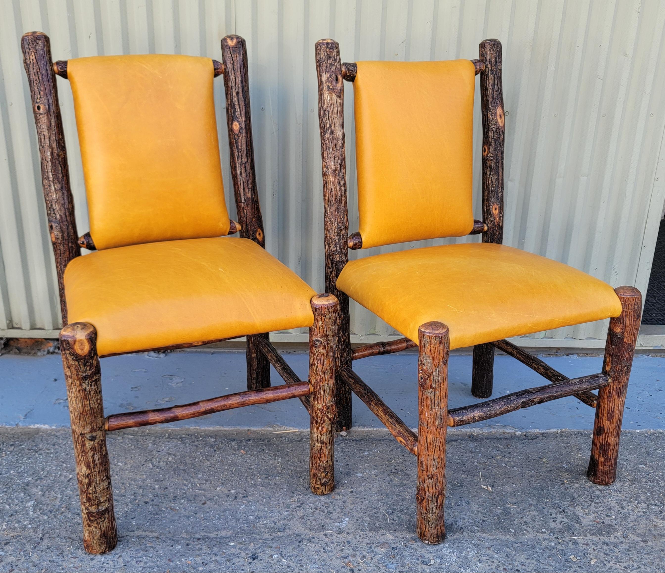 Le sedie Old Hickory sono rivestite in pelle sia per le sedute che per gli schienali.  patina. La coppia di sedie è pesante e robusta. La pelle è italiana di alta qualità.