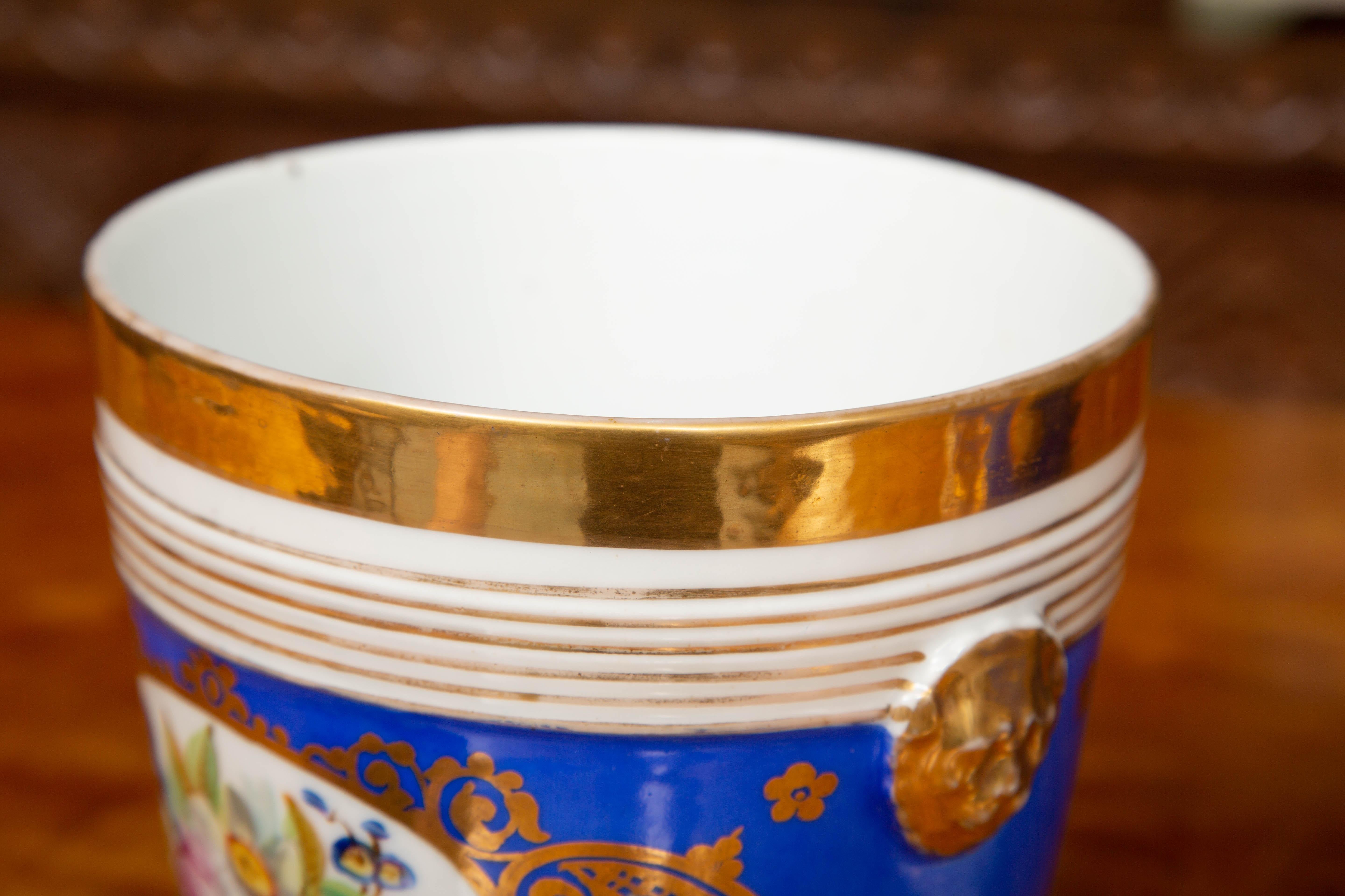 These are a classic pair of French Old Paris cache-pots. The blue ground is decorated with a central floral bouquet surrounded by an elaborate gilt design. Also the design includes reeded horizontal gilt stripes a wide top gold band and impressions