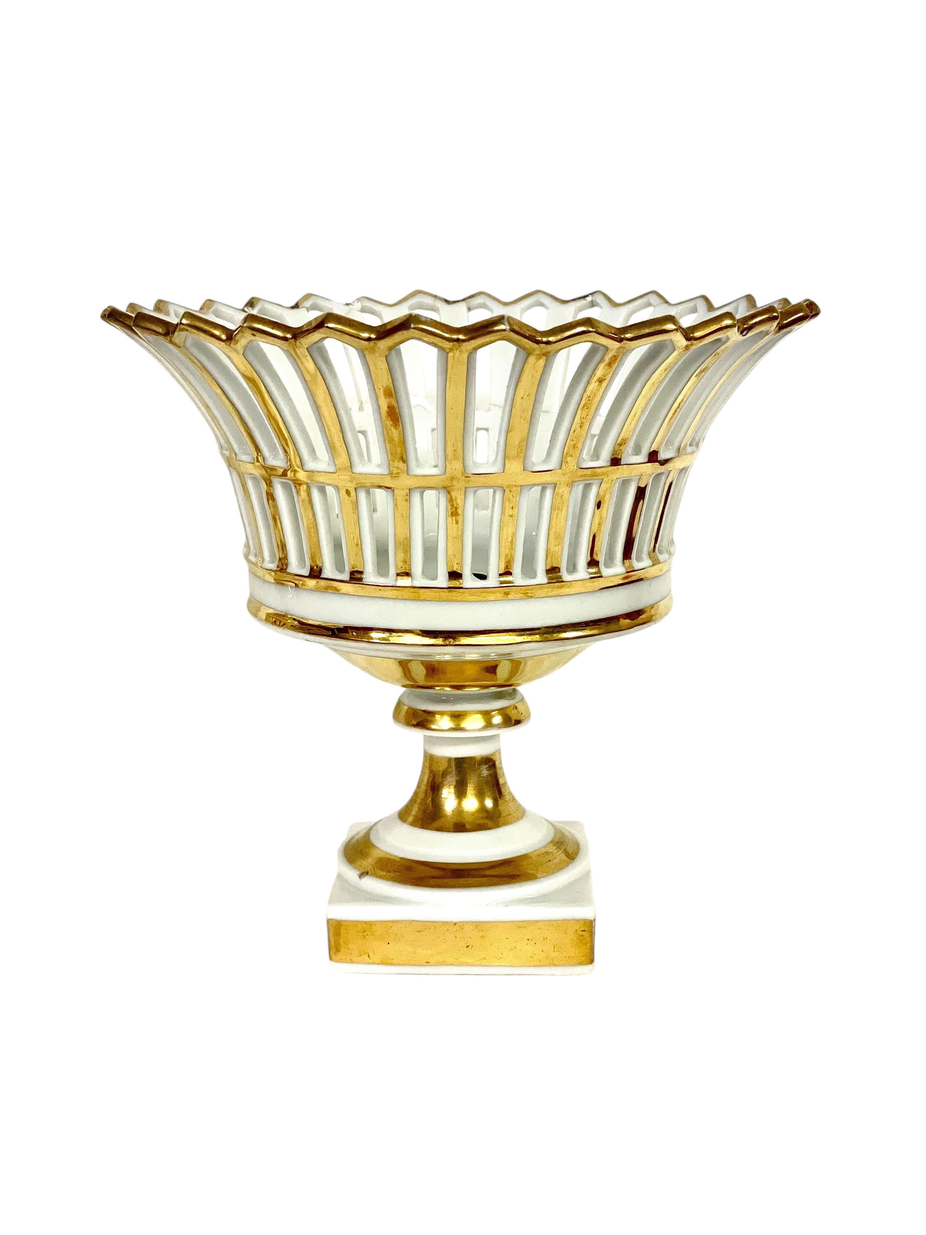 An elegant pair of old Paris Porcelain openwork circular baskets, dating from the 19th century Empire period, and embellished with fine gilding throughout. These very decorative pieces, with their crenellated rim and heavy, square bases, would be