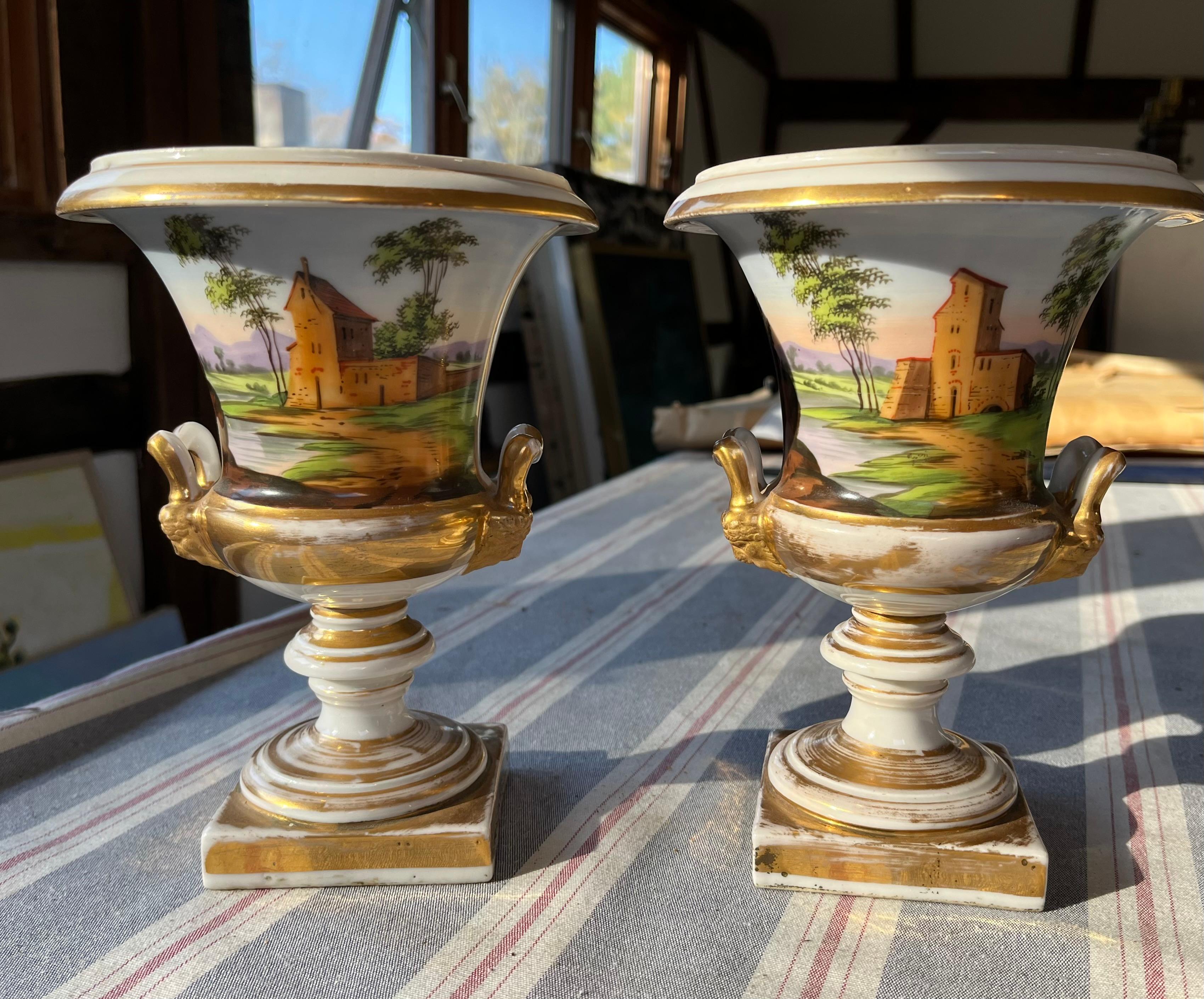 Coppia di urne in porcellana Vieux Paris a forma di Campagna con figure maschili e femminili dipinte su un lato di ciascuna e antiche rovine sul retro, decorazione dorata. Circa 1800, Francese. 