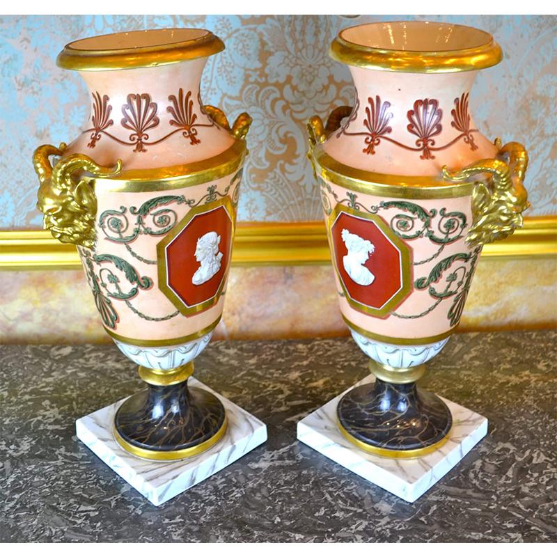 A fine pair of early French Empire porcelain vases. Each vase has large gilded satyr’s head to the sides, anthemion decoration to the tops along with scroll work around the sides flanking cameos on each side with painted classical heads. One pair