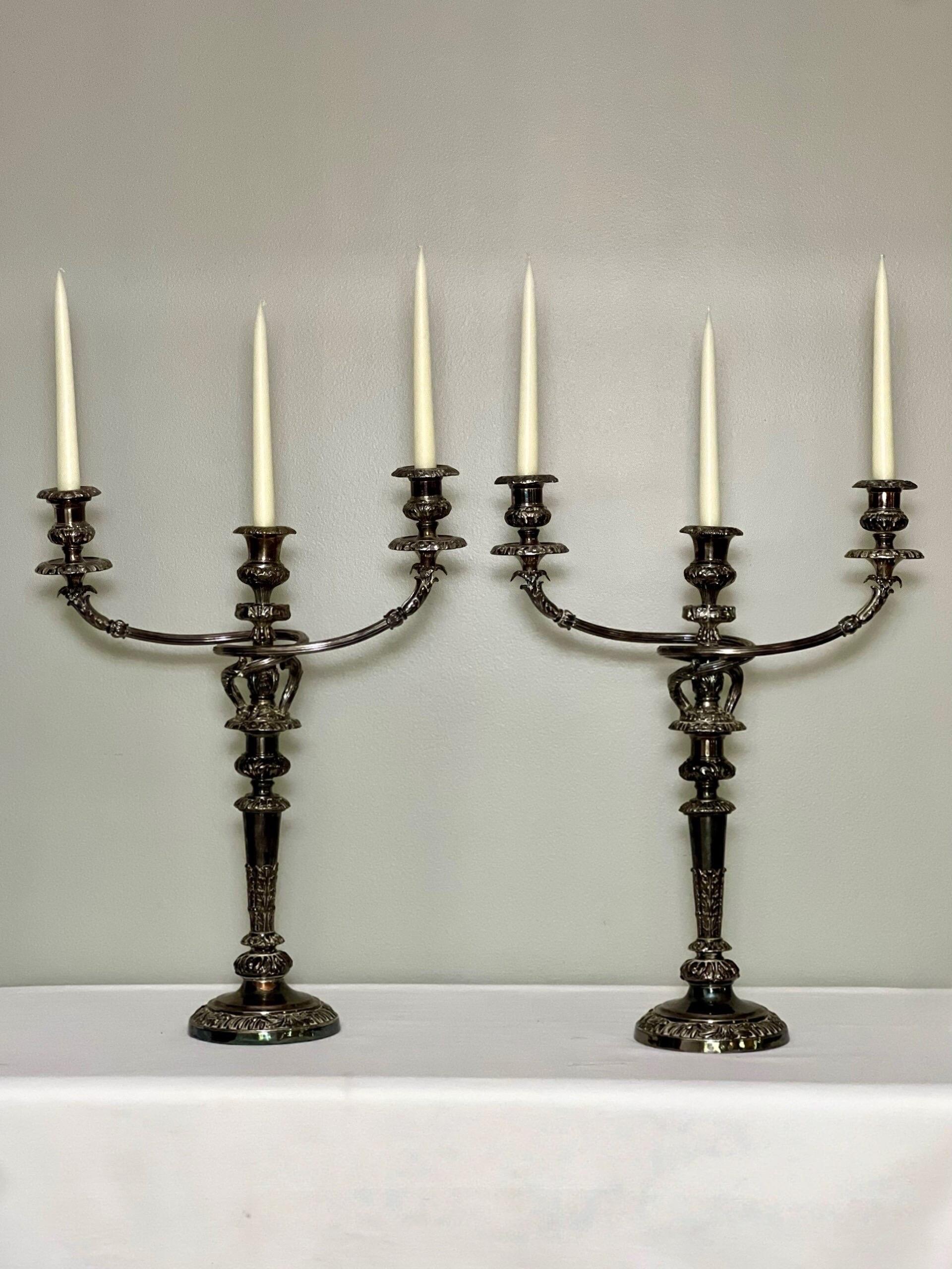Gorgeous early 19th century pair of Old Sheffield Plate three light candelabra by the renowned Matthew Boulton.  Gracefully curved arms with fluted detail and acanthus leaves intertwine around the central column and branch out to create a dramatic