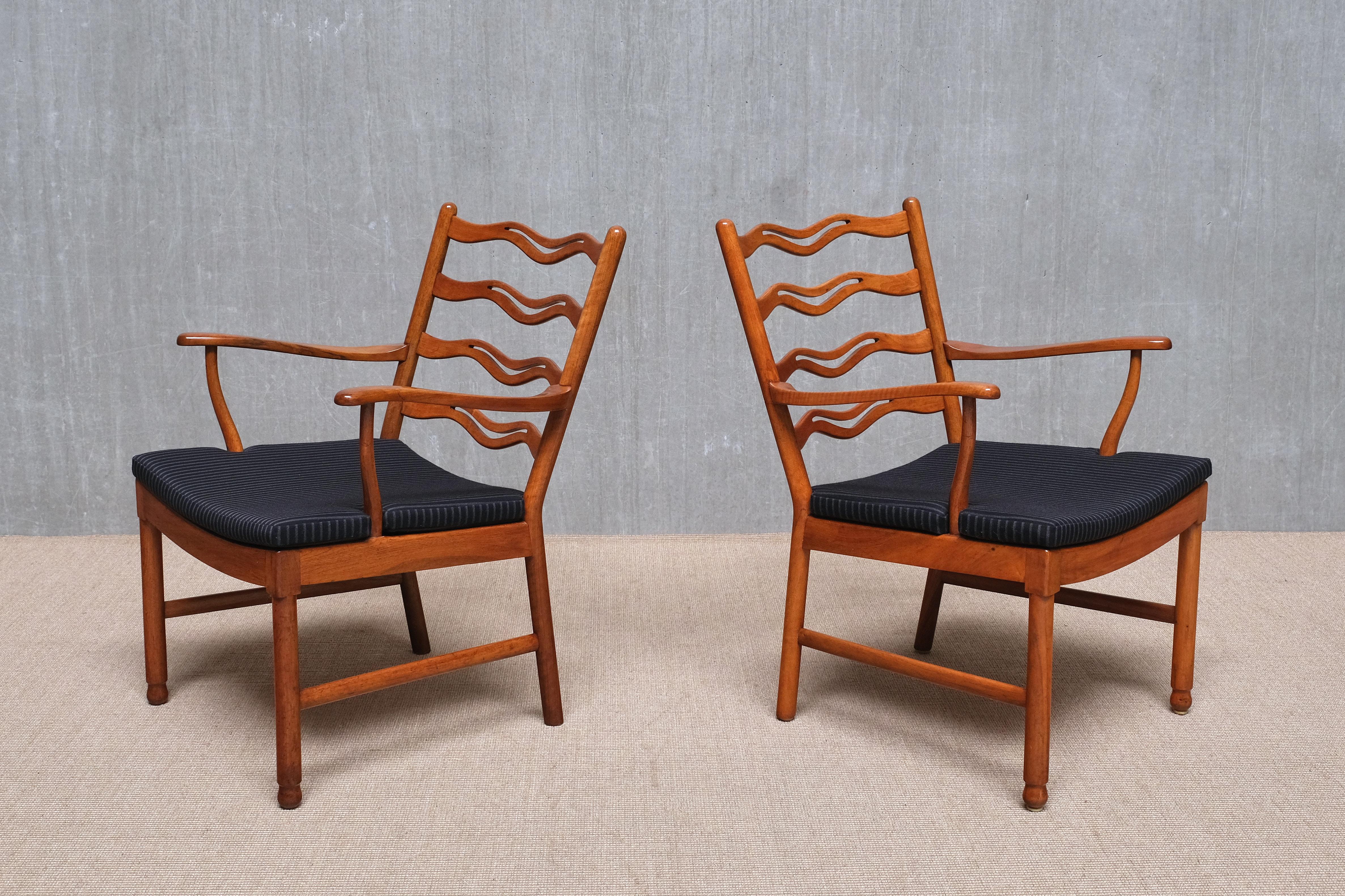 Cette rare paire de fauteuils a été conçue par Ole Wanscher et produite par Fritz Hansen au Danemark au milieu des années 1940. Les deux chaises ont conservé leurs labels de production d'origine, indiquant le numéro de modèle 1755 et les dates de