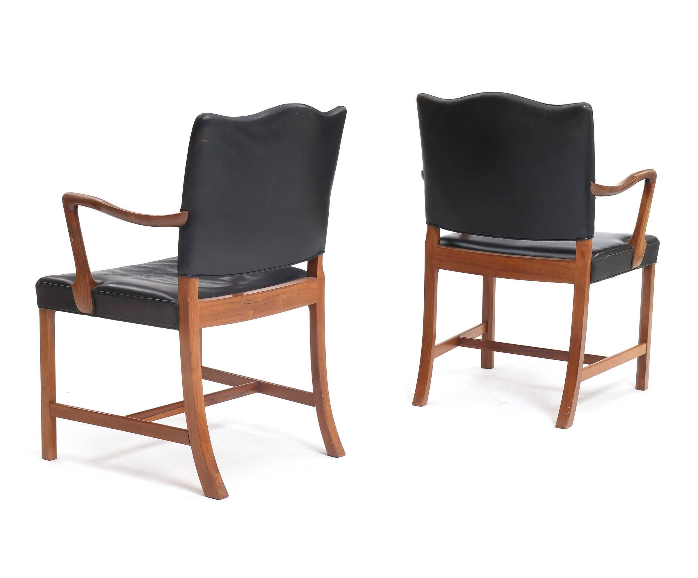 A fine pair of rosewood armchairs, seat and back upholstered with original black leather. Made and marked with label by cabinetmaker A.J. Iversen, circa 1960s. Exceptionally good condition. Proper chairs made by a cabinetmaker - each chair made one