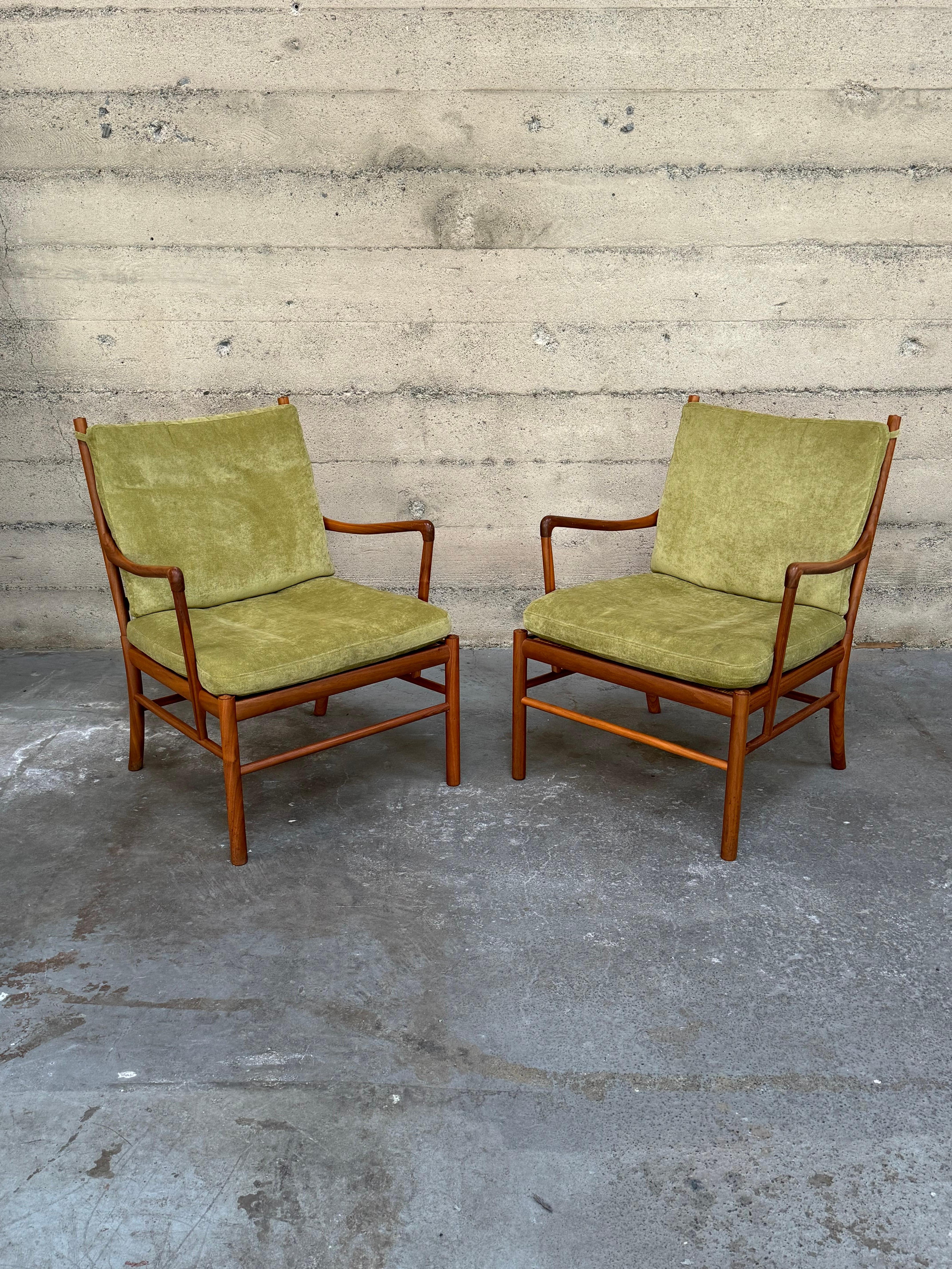 A pair of Ole Wanscher Colonial 149 armchairs in walnut, with cane seats and  green fabric cushions. These are newer production pieces produced within the last 25 years or so. Sculptural flowing frames with gracefully shaped arms and turned back