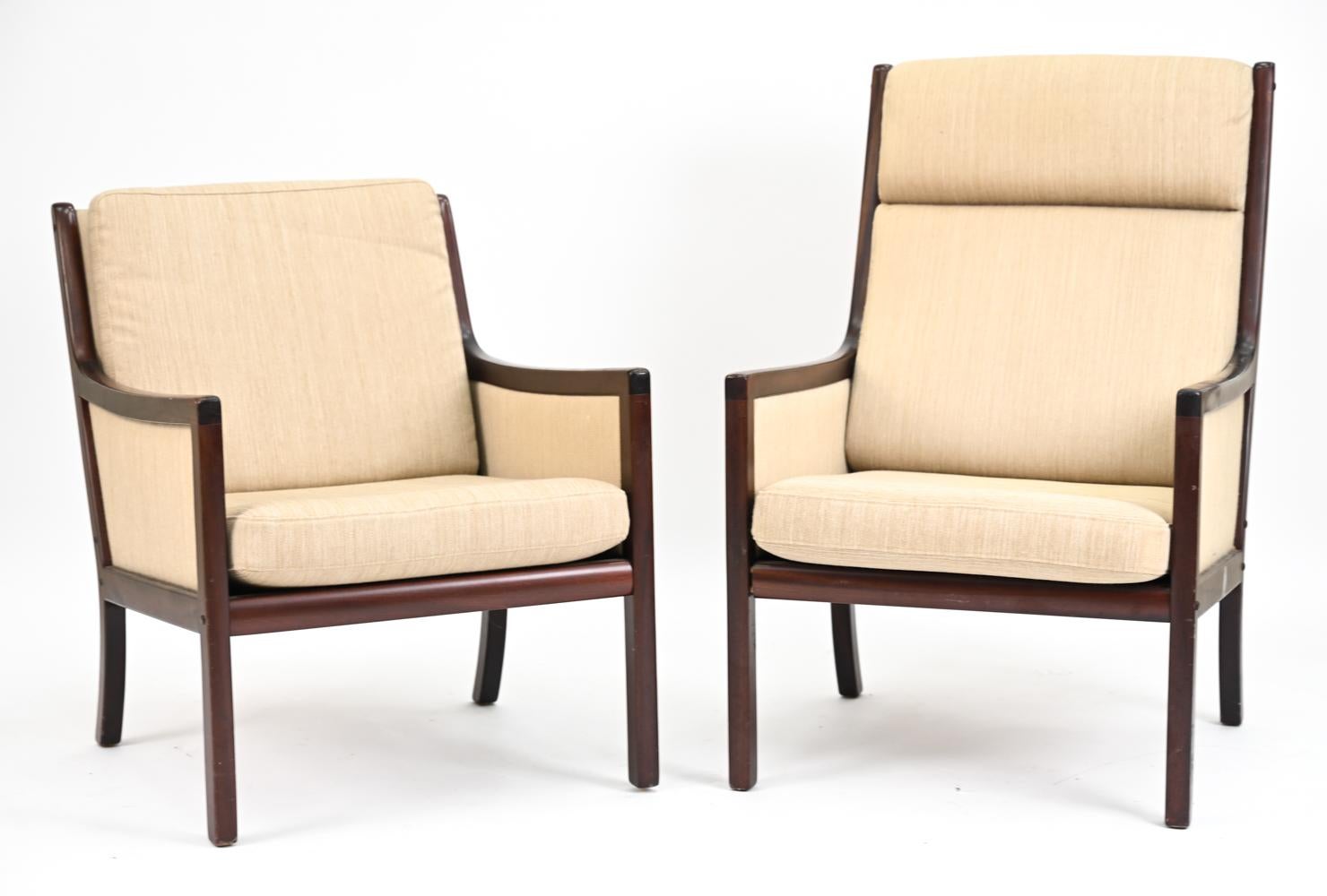 A handsome pair of Danish mid-century lounge chairs of a more traditional air, designed by Ole Wanscher for Poul Jeppesen. With Poul Jeppesen and Danish Control decals underneath. With fine mahogany frames and neutral beige upholstery. Inspired by