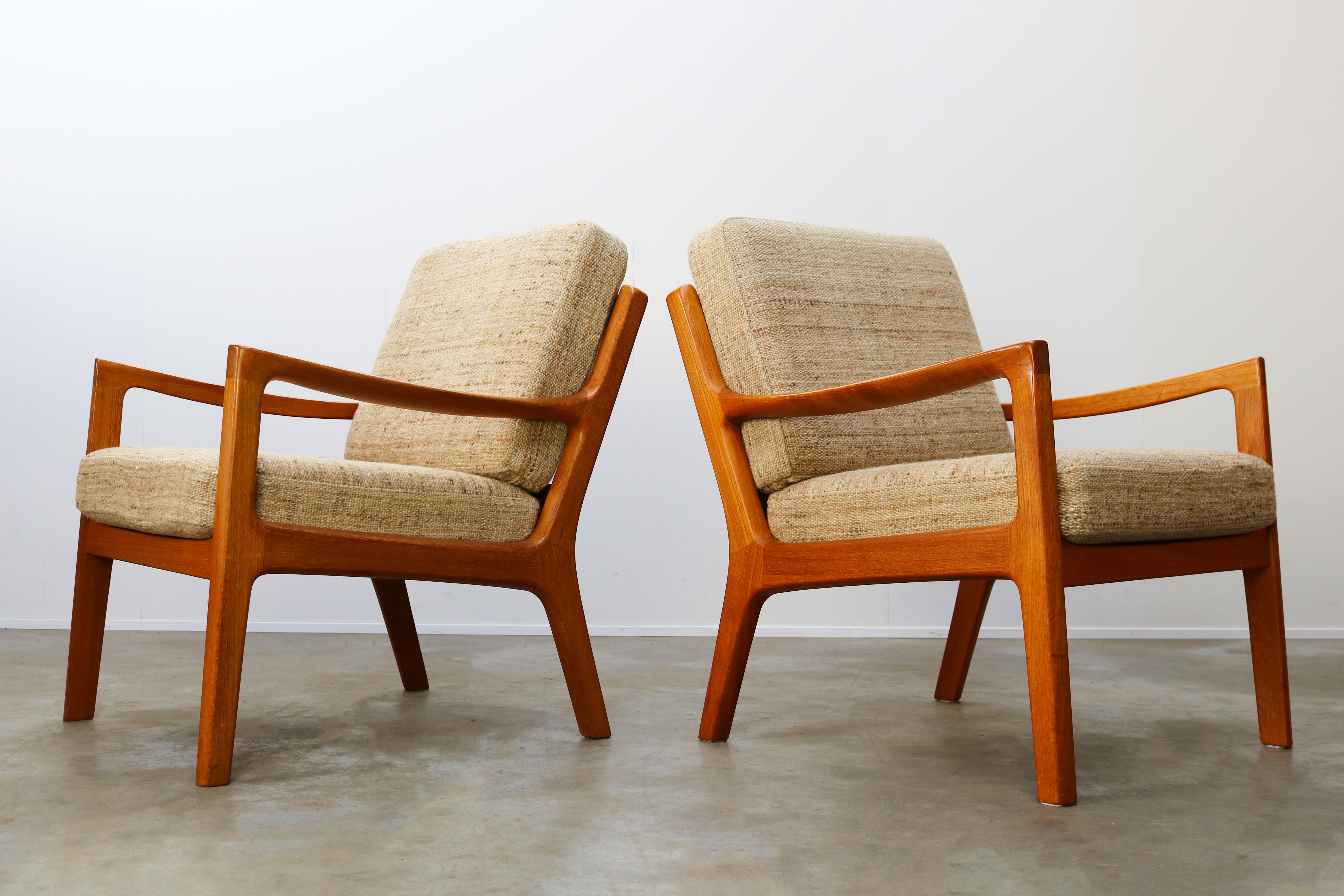 Wonderful pair of Danish design ''Senator'' lounge chairs in teak by Ole Wanscher produced by P. Jeppesen in the 1950s. The chairs have a solid teak organic sculpted frame and their original white wool with grey / beige upholstery. Chairs are in