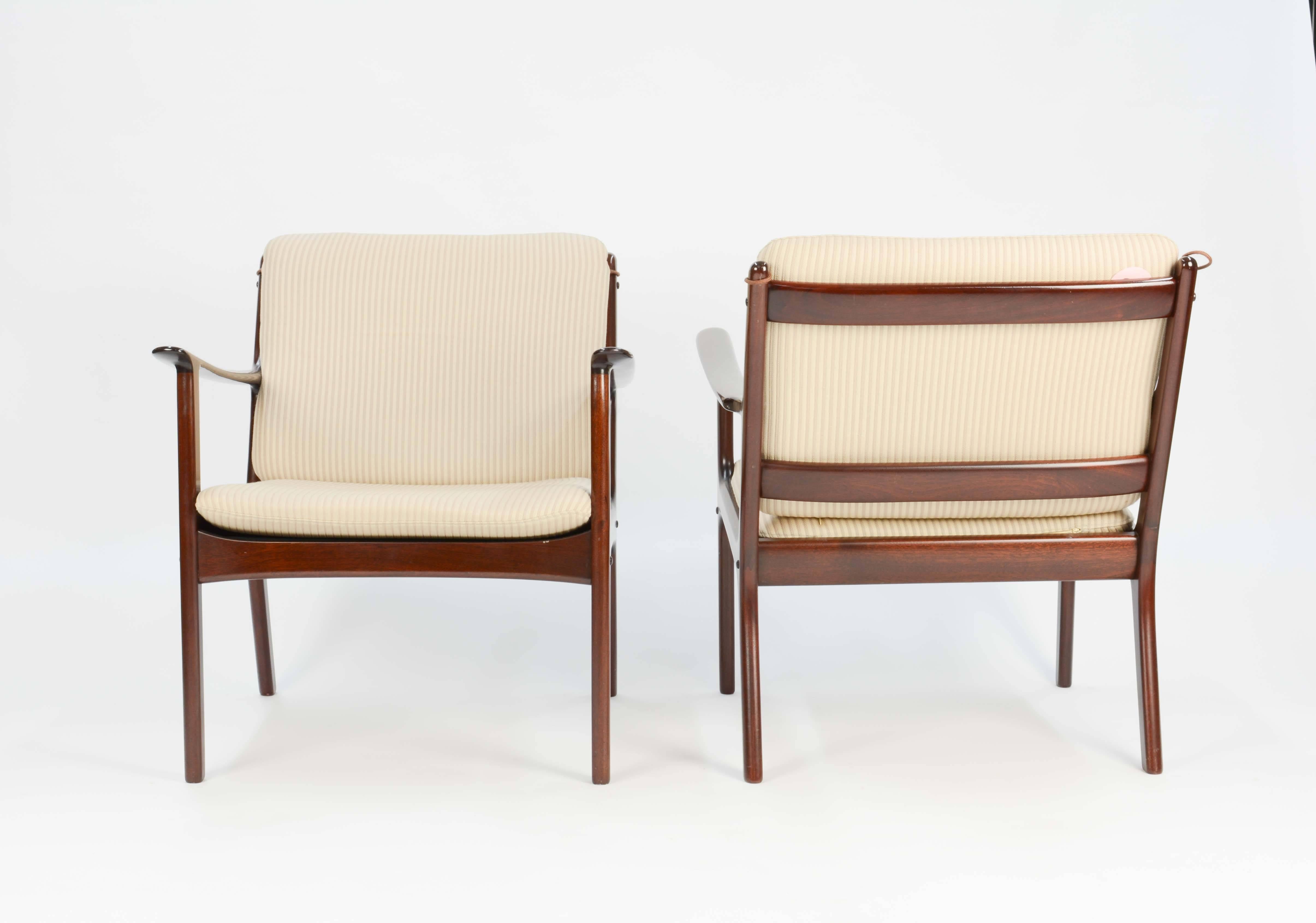 A pair of Ole Wanscher's club chair JP112 for P. Jeppesens Møbelfabrik of Denmark in mahogany with pin stripped fabric.

The 1950s are the start of the Danish Modern movement and features Wanscher's signature arms and JP Mobelfabtik's beautiful