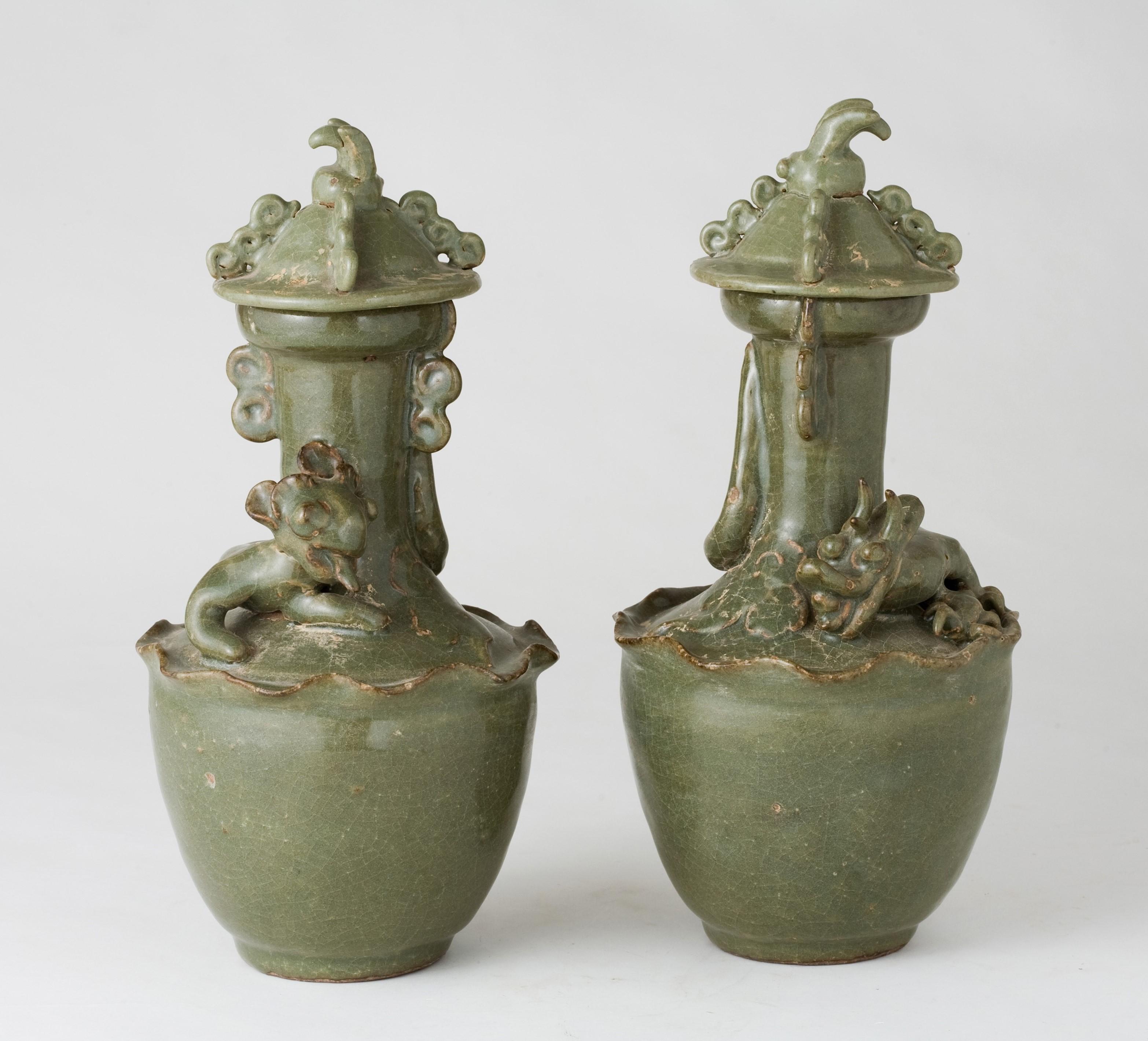 Questa coppia di vasi in celadon è interamente ricoperta da uno spesso smalto verde oliva, che mantiene una morbida lucentezza naturale. Una rete di crepitii si diffonde sulla superficie. Lungo le creste e i bordi, lo smalto si è assottigliato e