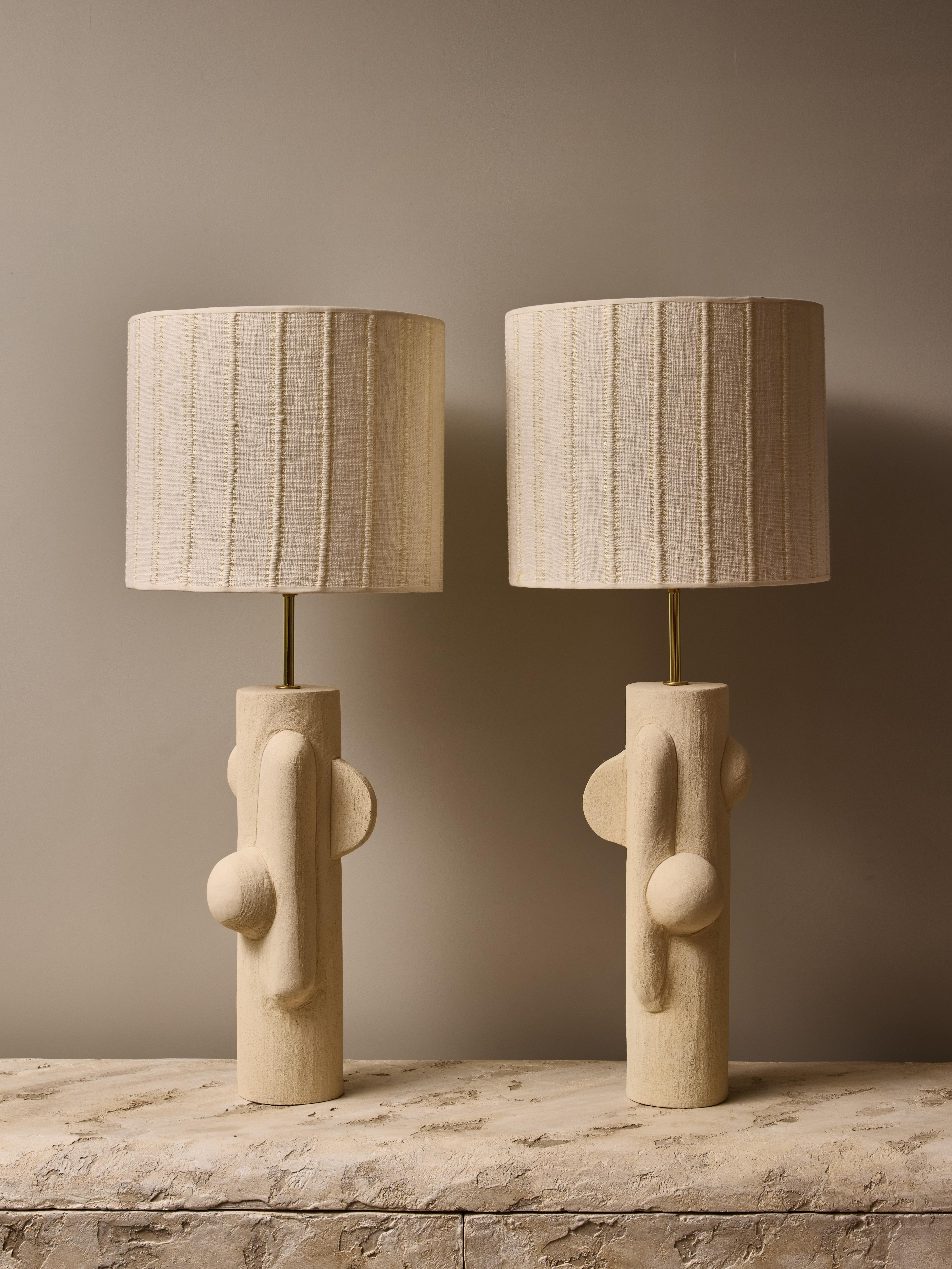 Pair of ceramic table lamps by the talented french contemporary artist Olivia Cognet.

These thin tubular shape lamps have mirrored design of soft geometrical shapes, brass hardware and topped with a custom lampshade.

Stamped on the