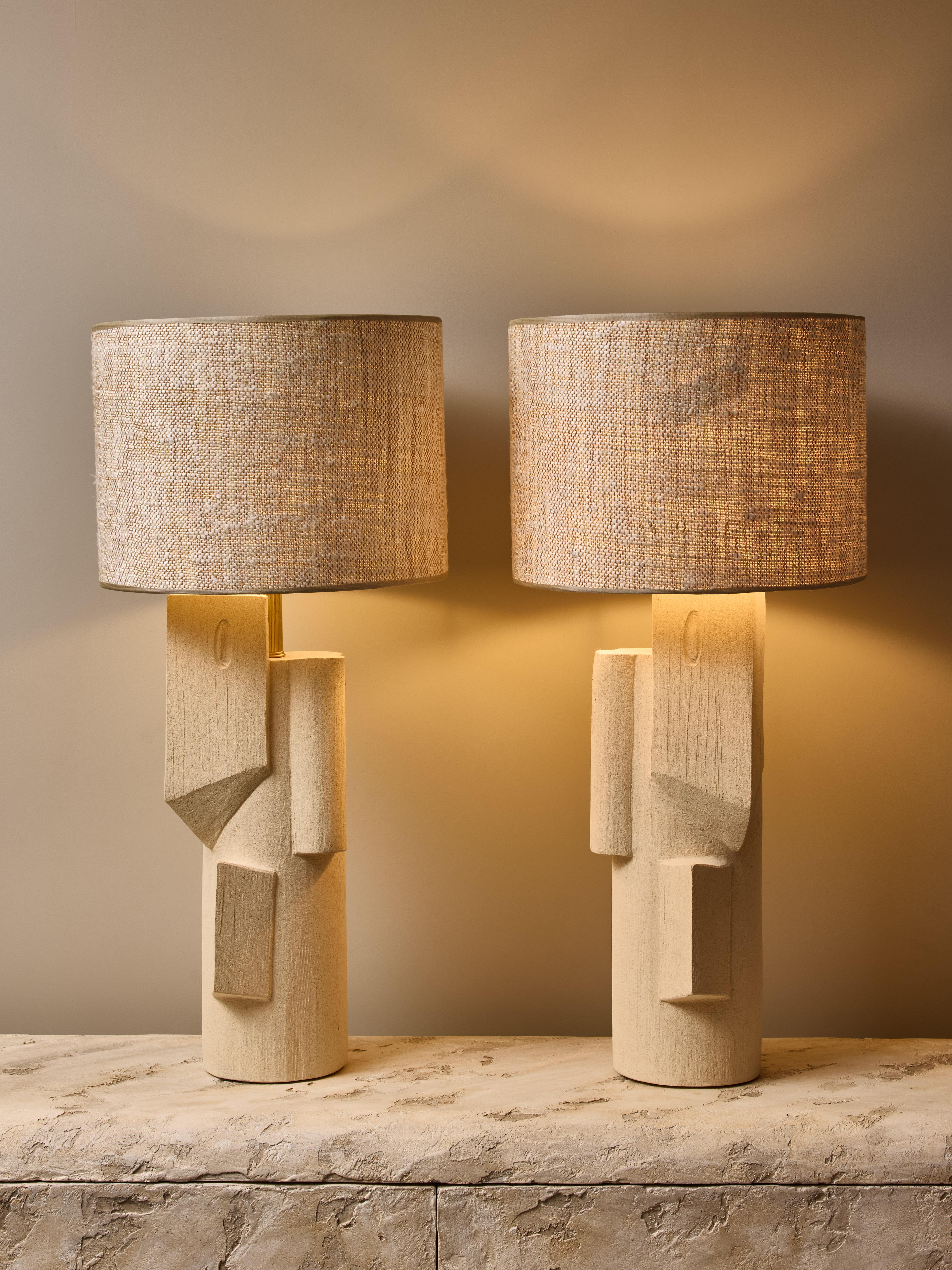 Pair of ceramic table lamps by the talented french contemporary artist Olivia Cognet.

These large tubular shape lamps have mirrored design of sharp geometrical shapes, brass hardware and topped with a custom lampshade.

Stamped on the
