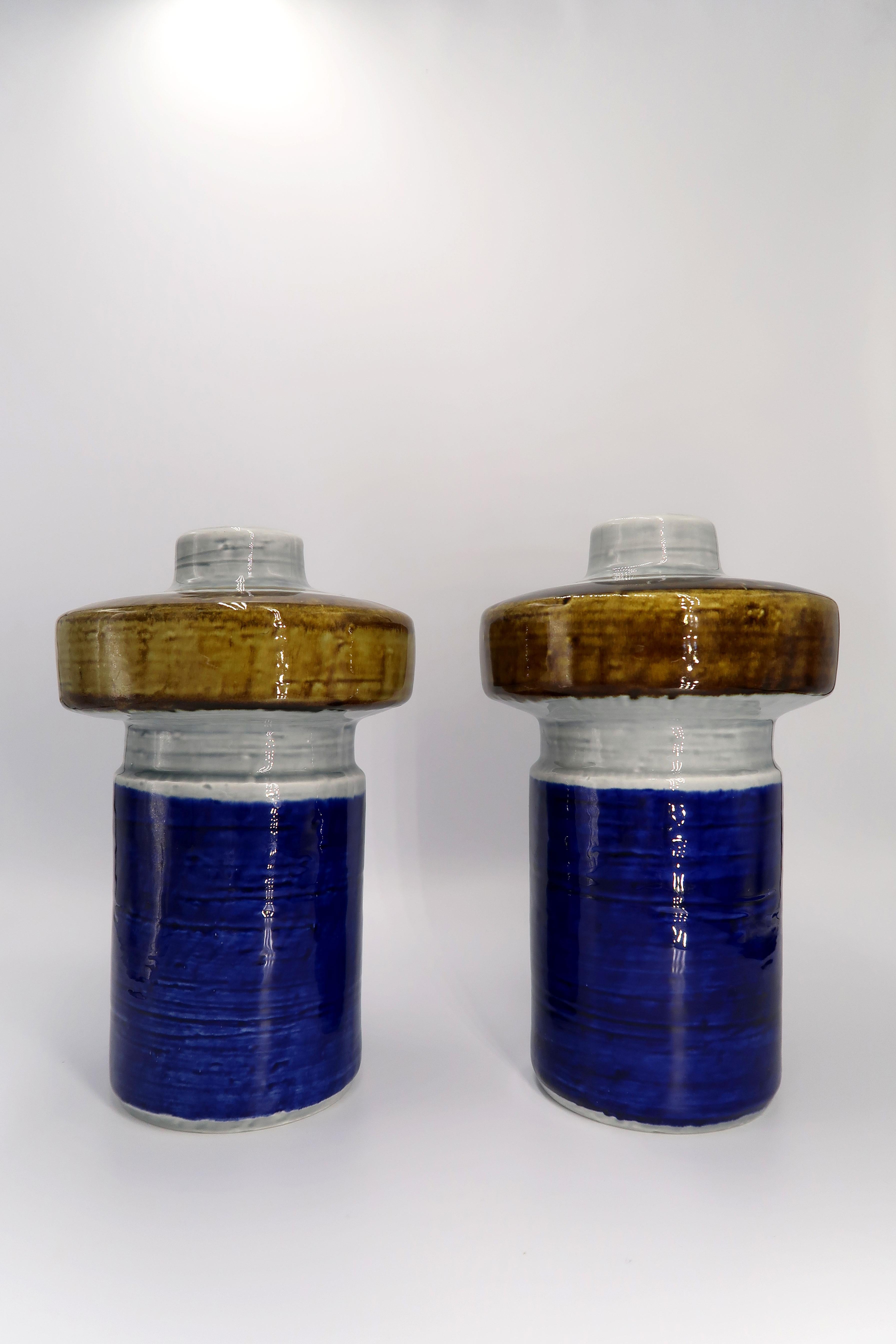 Beautiful color block Scandinavian Mid-Century Modern handmade, hand painted ceramic vases by designer Olle Alberius for Swedish Rörstrand in the 1960s. Cobalt blue base with light grey and bronze glazed top. Light grey glaze on the inside. From the