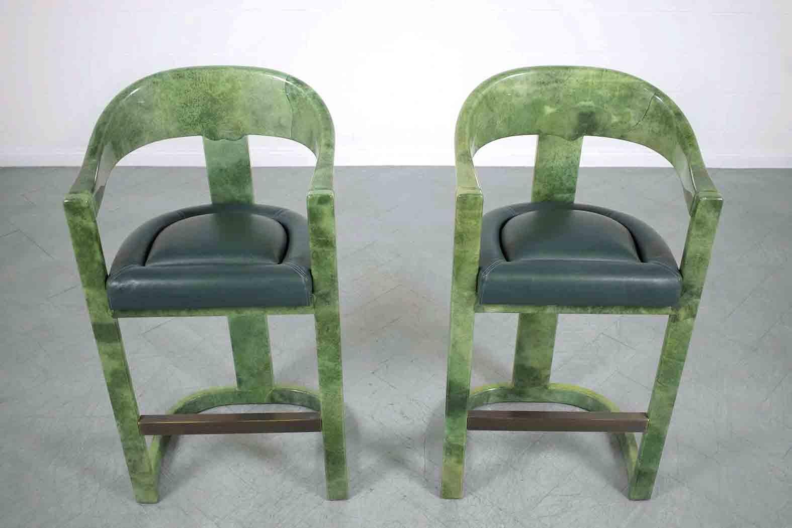 Experience the timeless elegance of our pair of Mid-Century Modern Karl Springer bar stools. In great condition, these stools are crafted out of solid wood, fully covered in goatskin, and meticulously restored by our in-house team of expert