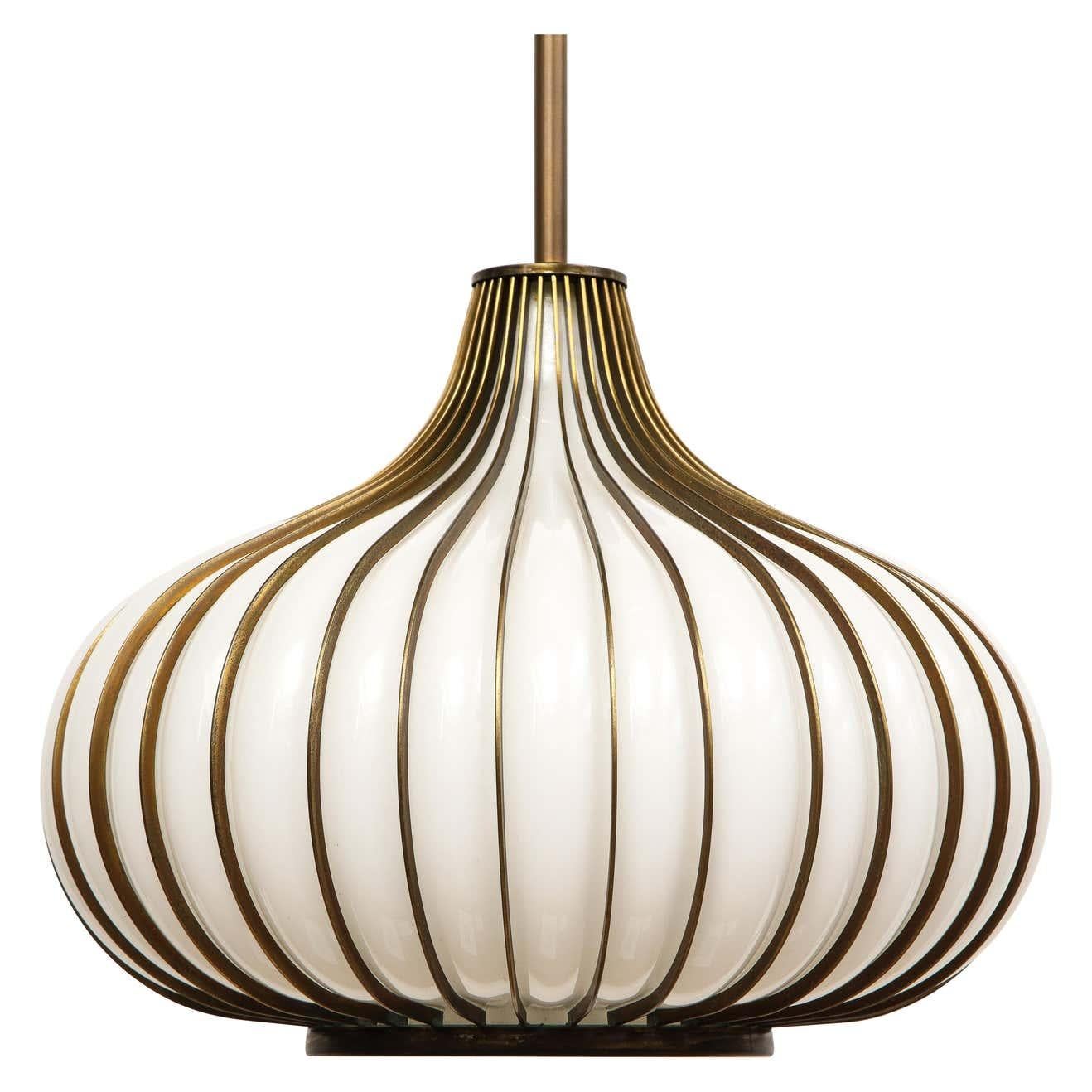 Pair of Onion pendant lamps, glass, brass, California Modern. Medium scale 15 inch swag lights with white hand blown glass, encased by edge metal with an antique brass/bronze finish. Designed and manufactured by Lightcraft of California in the