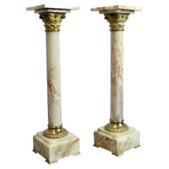 Pair of onyx pedestal columns with gilt bronze capitals and bases, 19th century