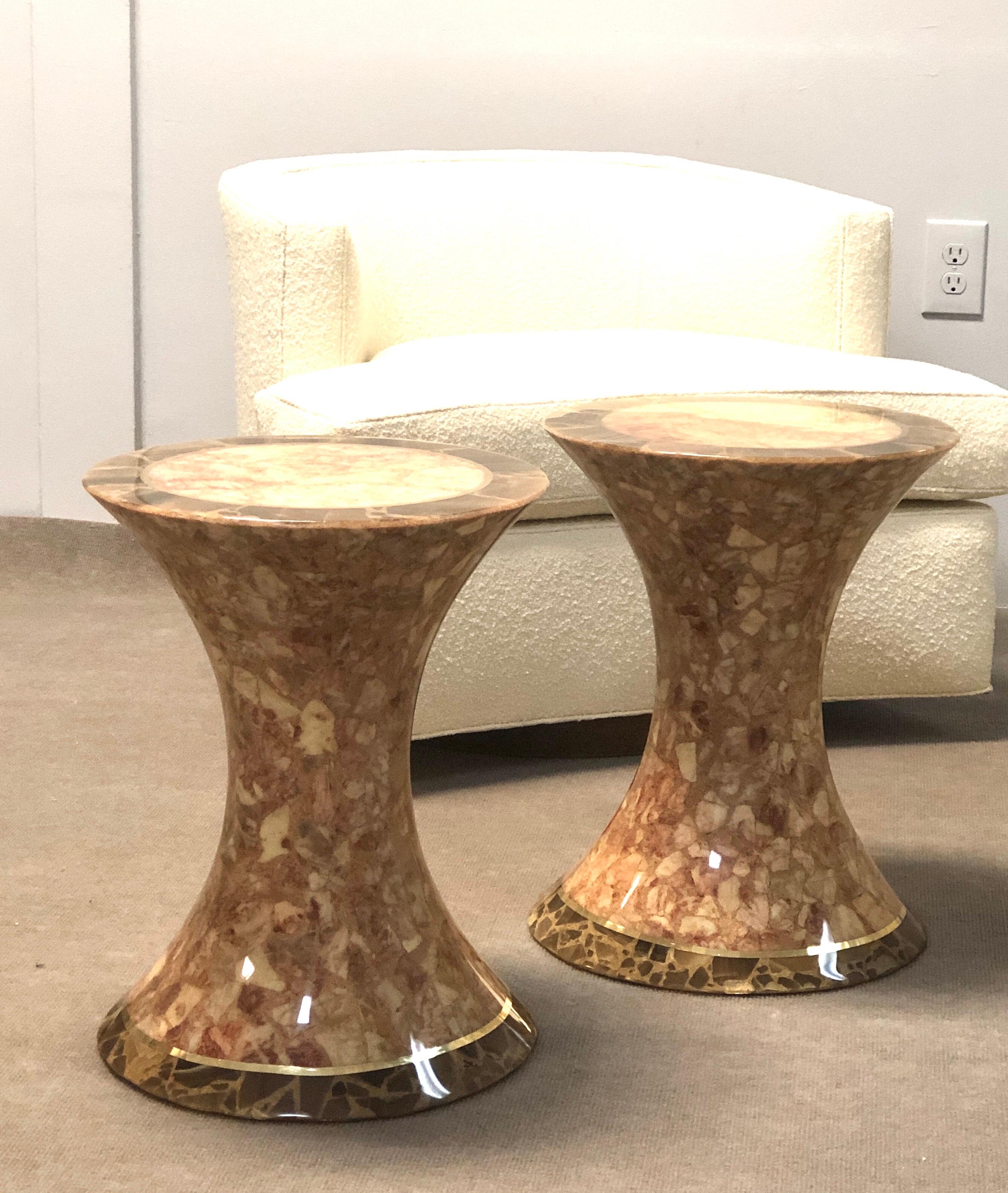 A pair of onyx tables. Modern hourglass form. Brass detail and a glossy finish.