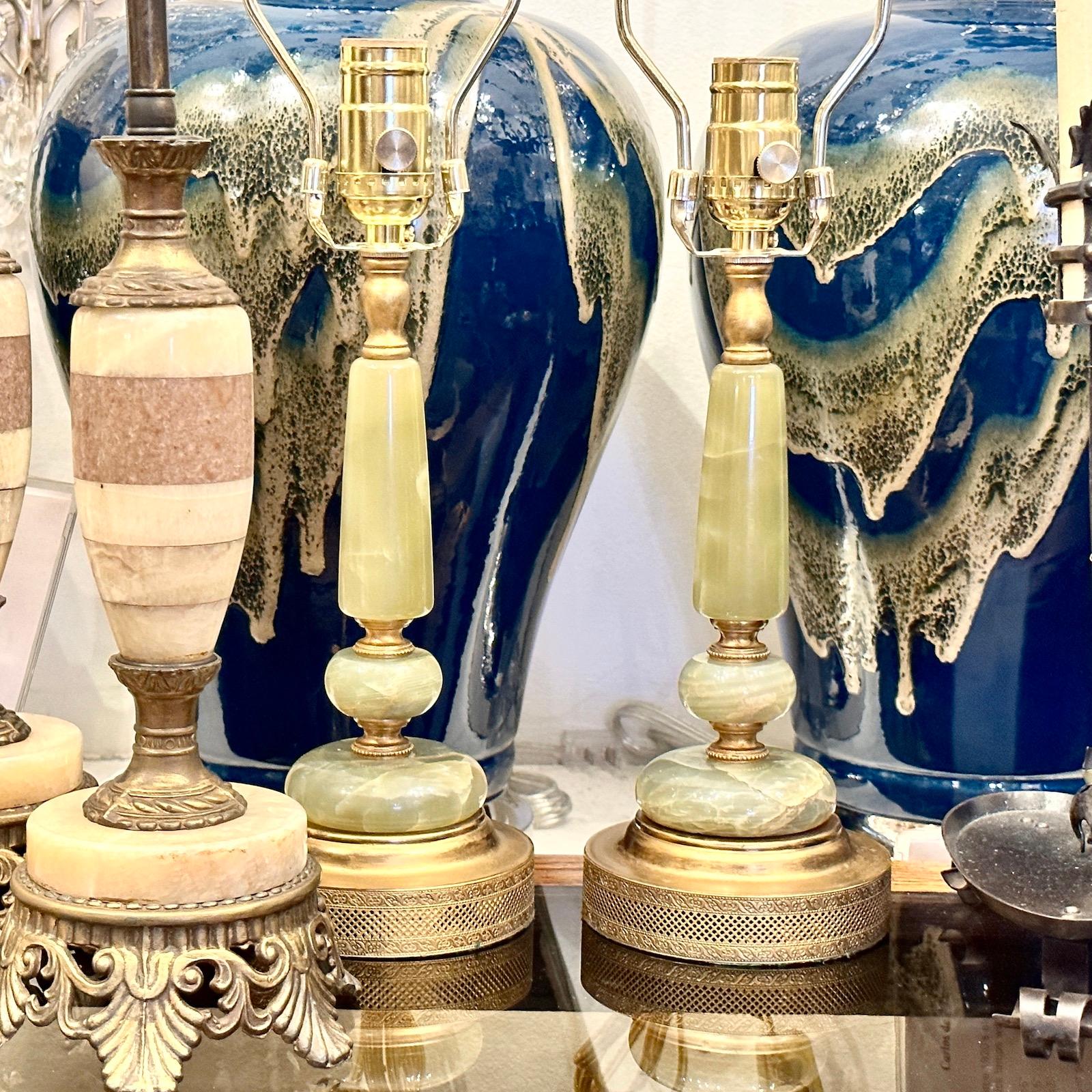 Paire de lampes de table en onyx français des années 1930 avec des bases dorées.

Mesures :
Hauteur du corps : 10 
Hauteur jusqu'à l'appui de l'abat-jour : 18