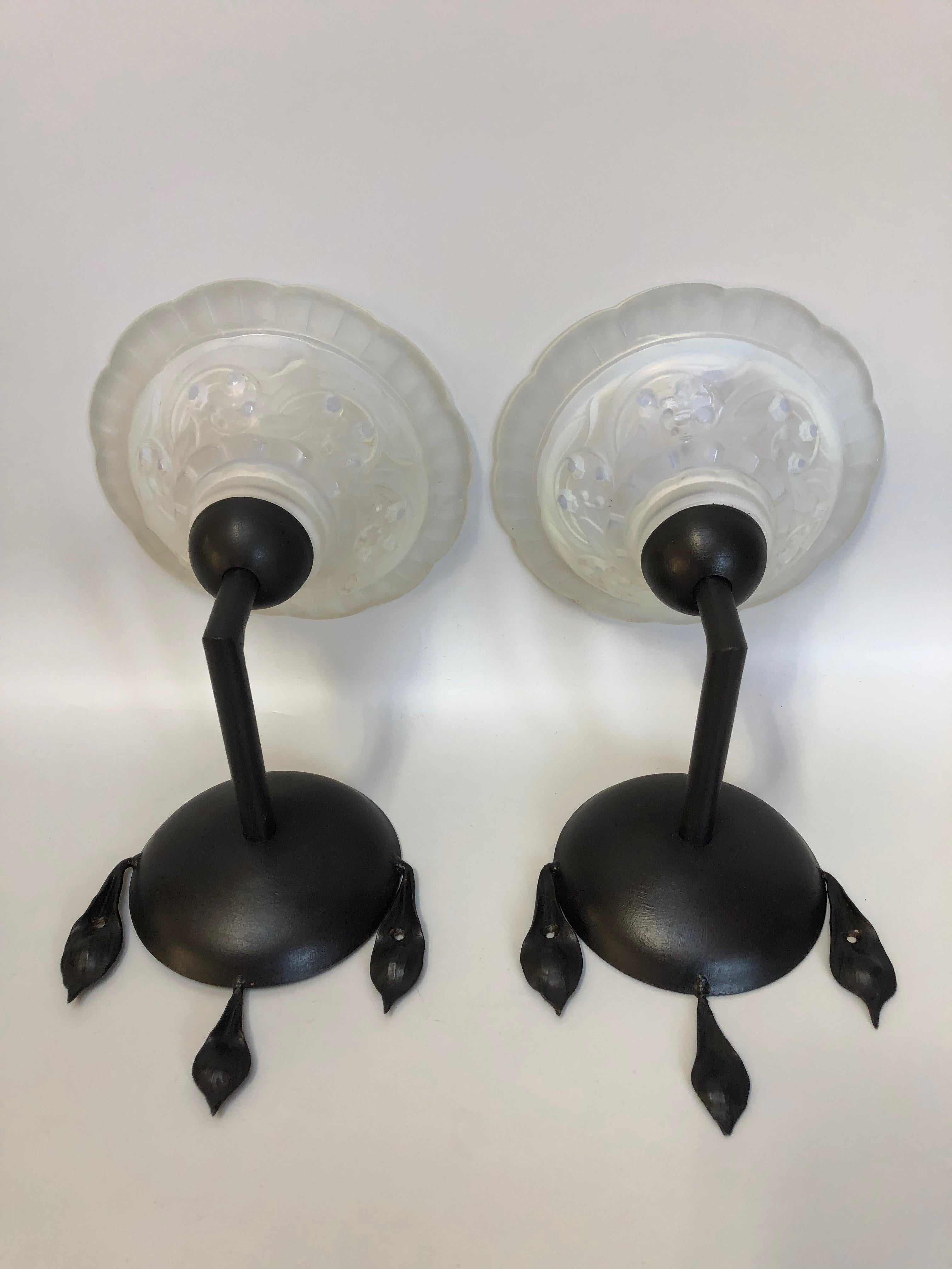 Pair of art deco sconces circa 1930, attributed to Maynadier
Wrought iron frame and opalescent molded glass cup decorated with lily of the valley.

Total height: 24cm
Width: 18cm
Depth: 23cm
Tulip diameter: 18 cm
Weight: 2.1 Kg