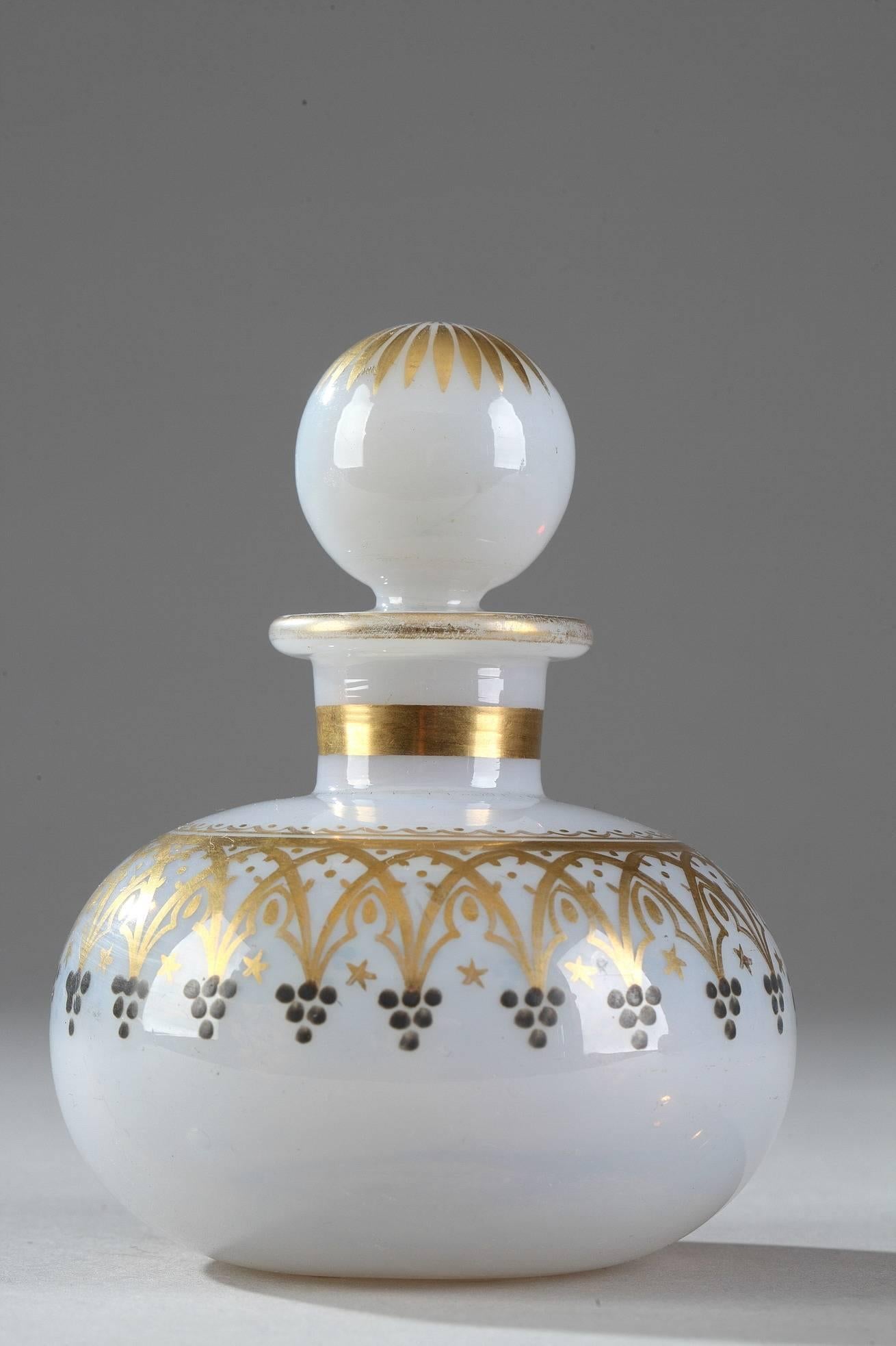 Pair of white soap bubble opaline flasks with their ball-shaped stoppers. The perfume bottles are each decorated with a frieze of gold Gothic arcades and blue forget-me-nots. Gilded bands adorn the neck, and gold petals decorate the top of the