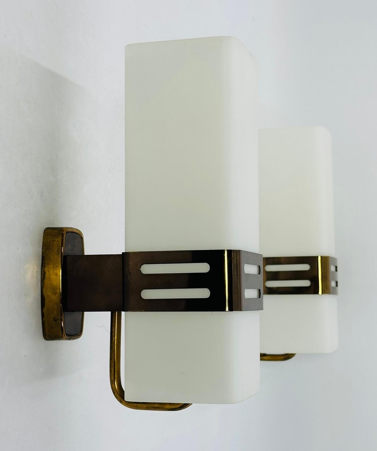 Añade un toque de elegancia moderna de mediados de siglo a tu espacio con esta impresionante Pareja de Apliques de Cristal Opalino y Latón de Stilnovo.

Los apliques se diseñaron y fabricaron en Italia en la década de 1960 y conservan las etiquetas
