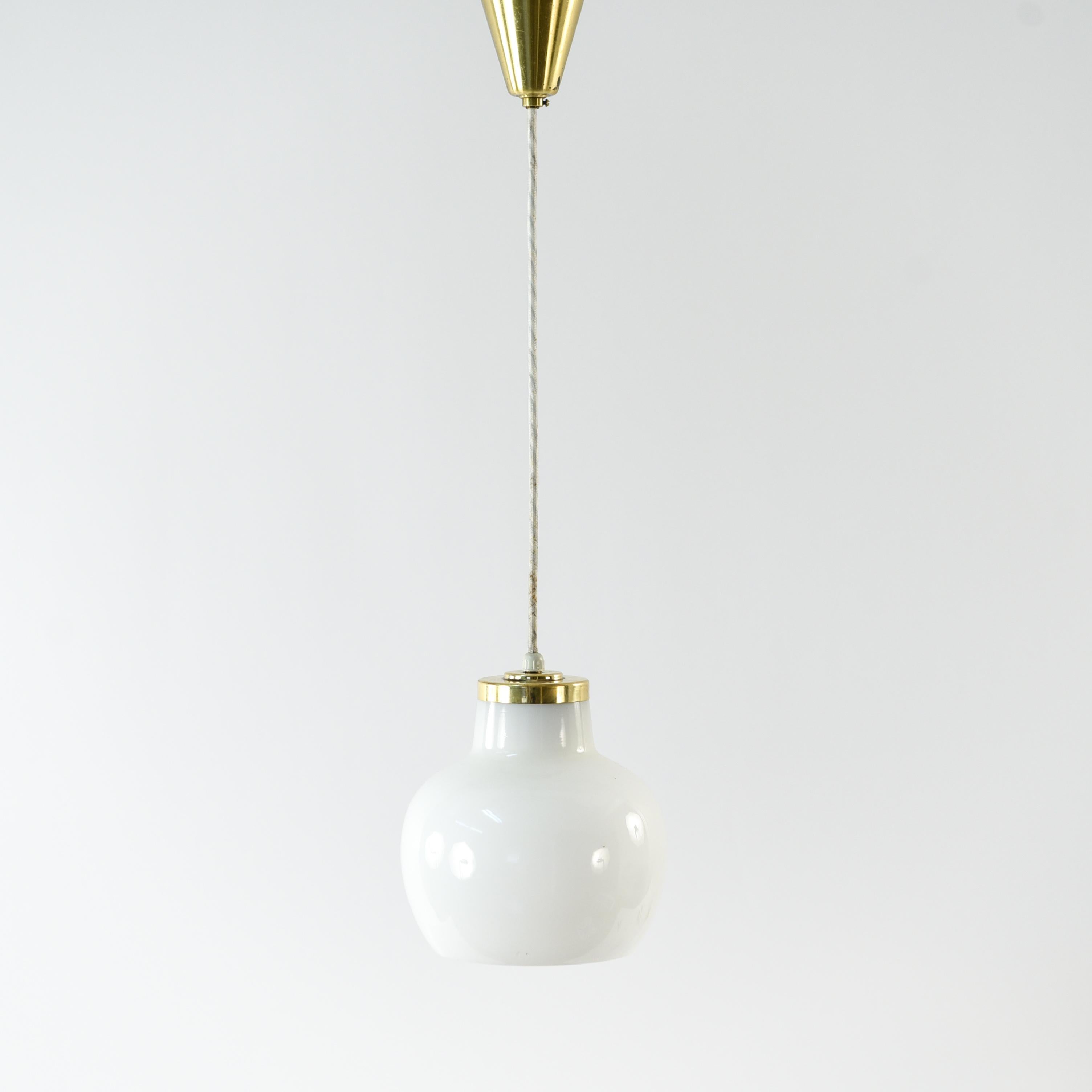 This pendant designed by Vilhelm Lauritzen and manufactured by Louis Poulsen is executed in handblown glossy white opal glass, with a brushed brass pendant tube. This pair has a sleek, modern look and can be used together or independently to create