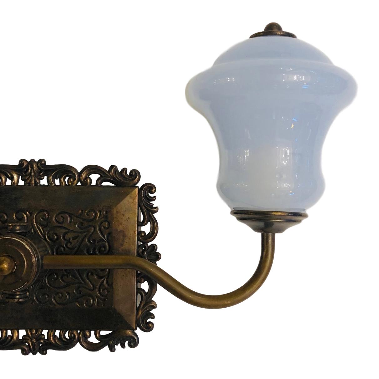 A pair of circa 1930s Italian two-arm bronze sconces with open-work borders and opaline glass shades.

Measurements:
Height 9